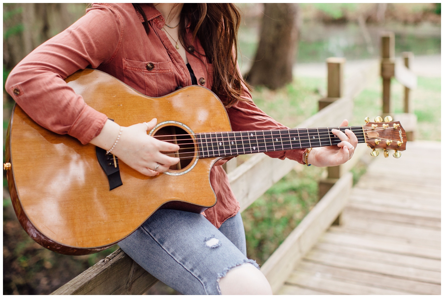 close up image of guitar being played by high school senior girl