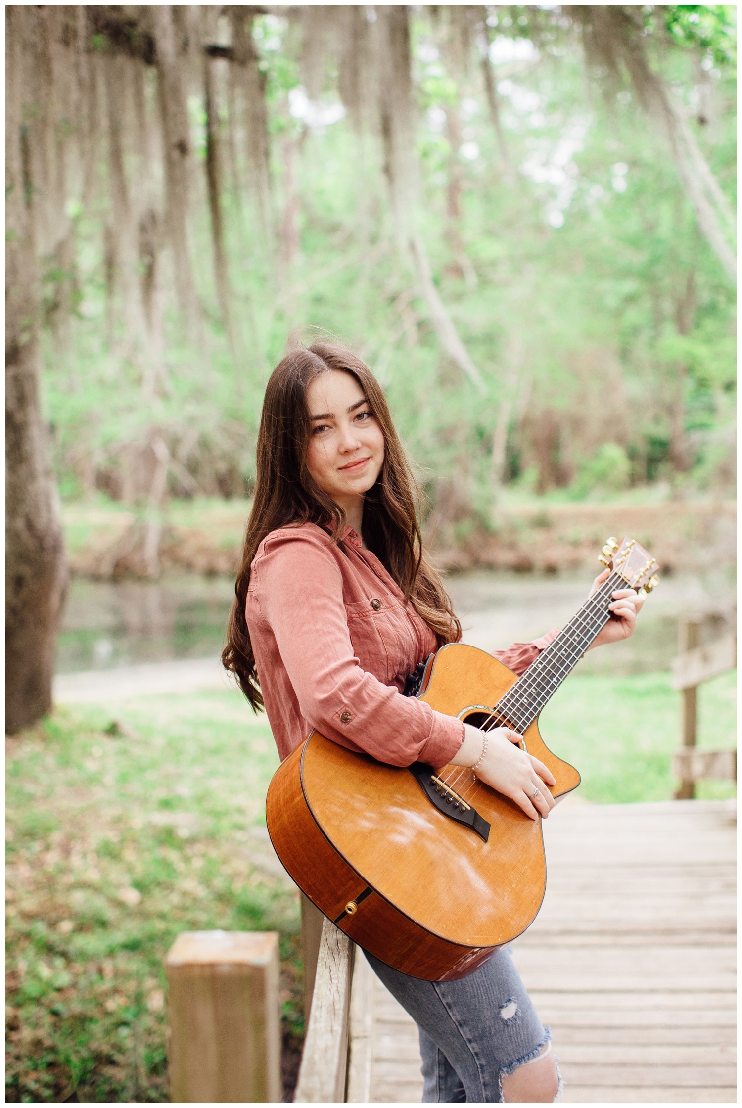 girl standing on bridge holding guitar Houston senior photos with guitar