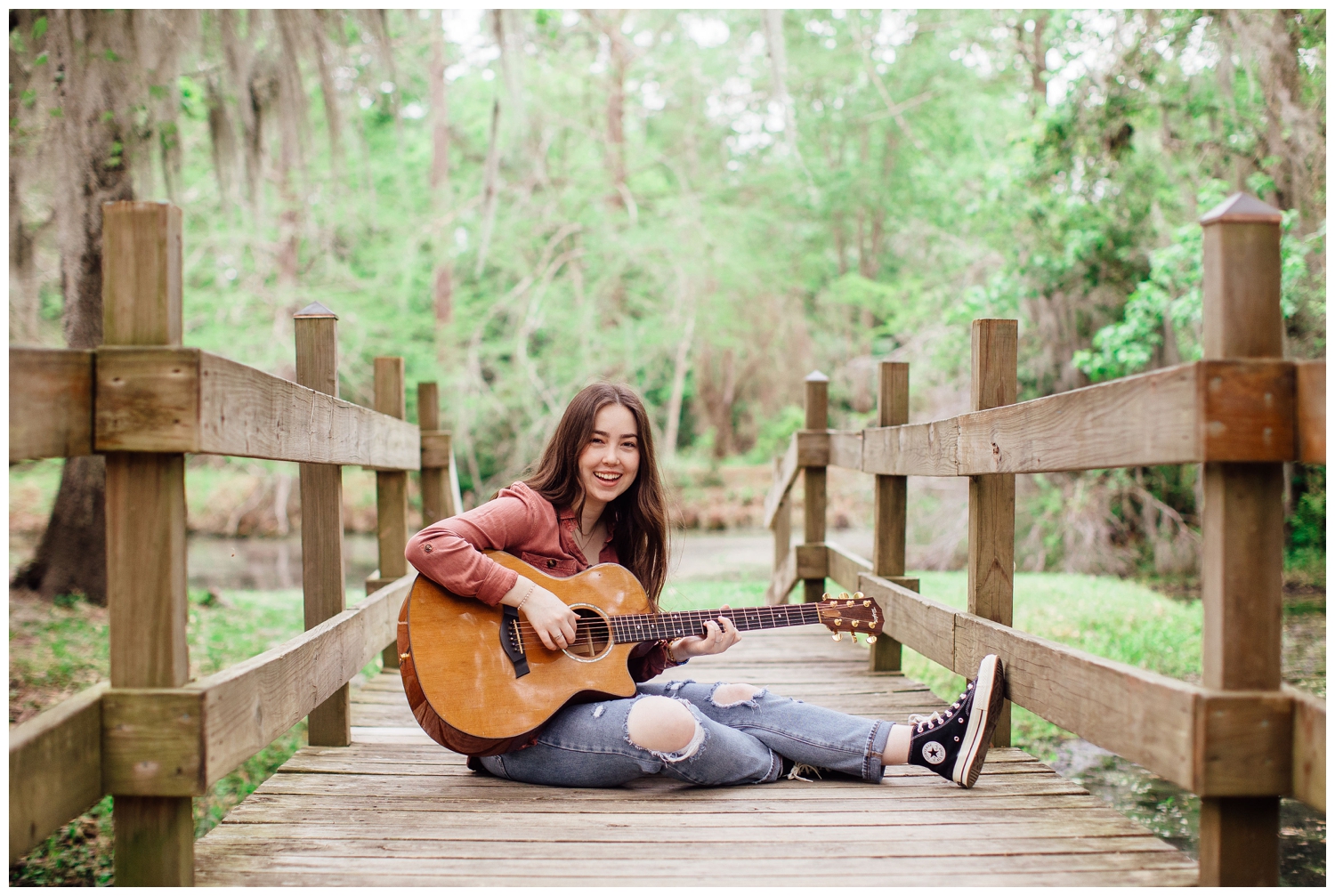 girl sitting on bridge with guitar Houston senior photos with guitar