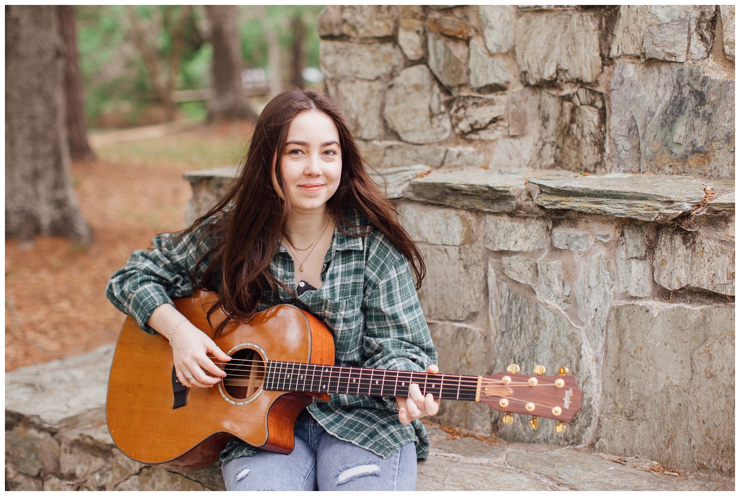 girl sitting on stone bench playing guitar