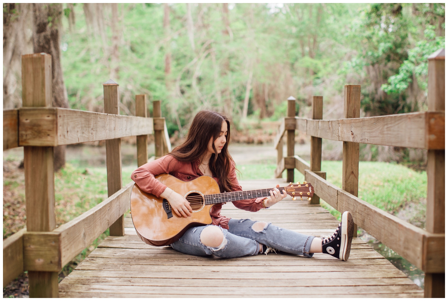 girl sitting on bridge Houston senior photos with guitar playing