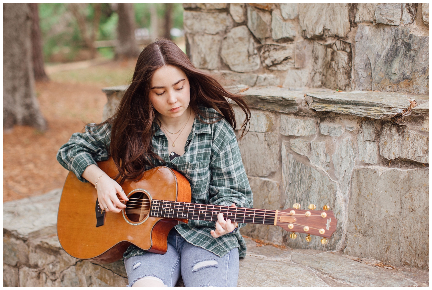 Houston senior photos with guitar in girls hand sitting on stone bench
