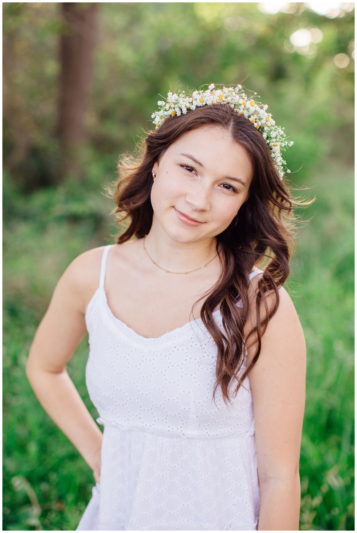 spring senior photos Houston with girl in white sundress wearing flower crown standing in a field