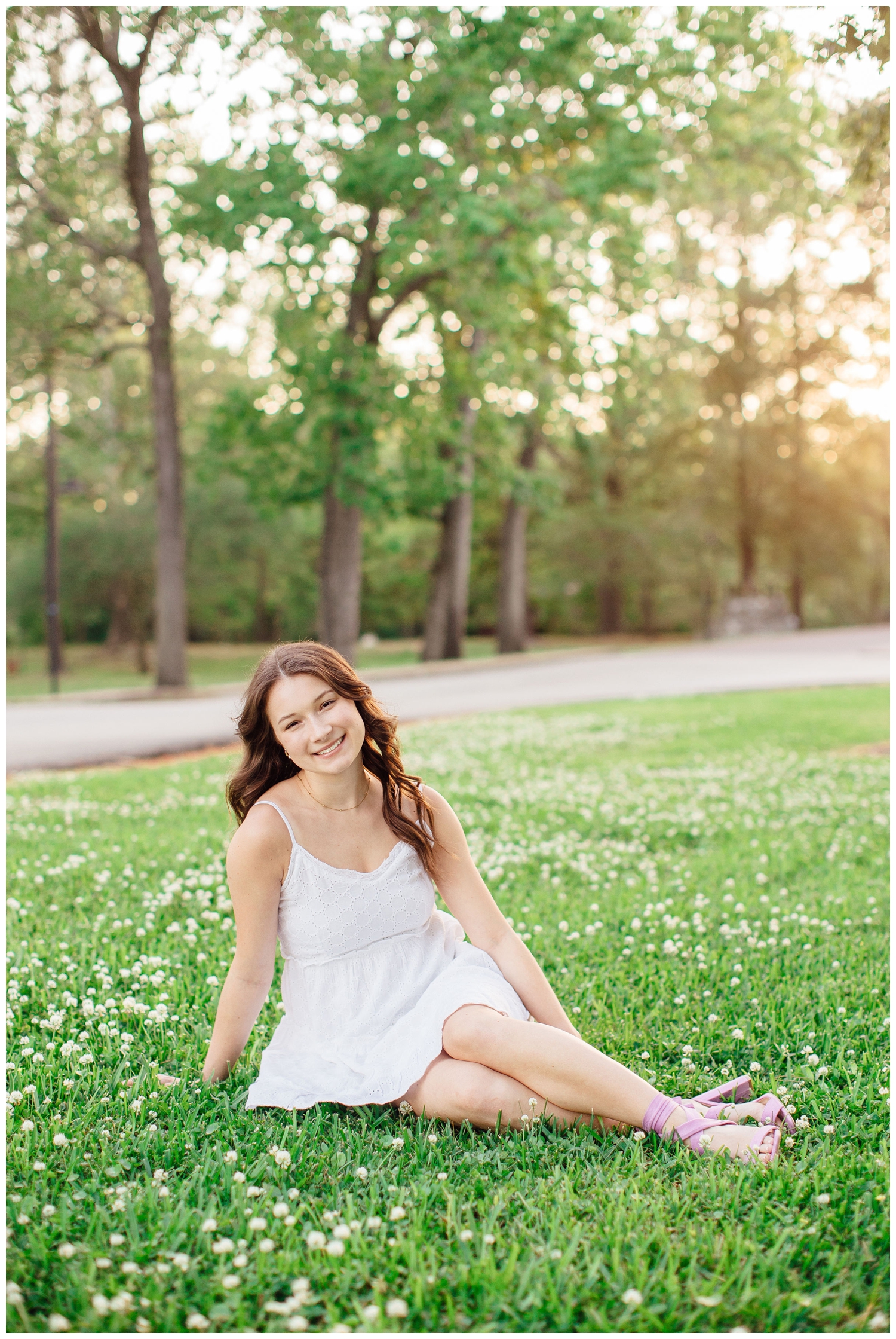 high school senior girl sitting in grass for senior photos Houston