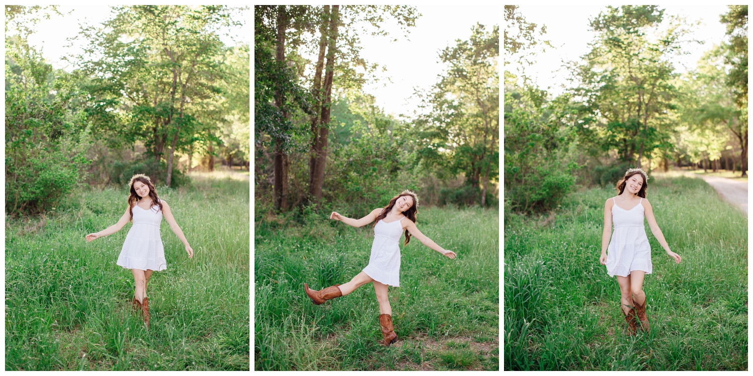 high school girl in white dress and boots frolicking in a field for spring senior photos Houston