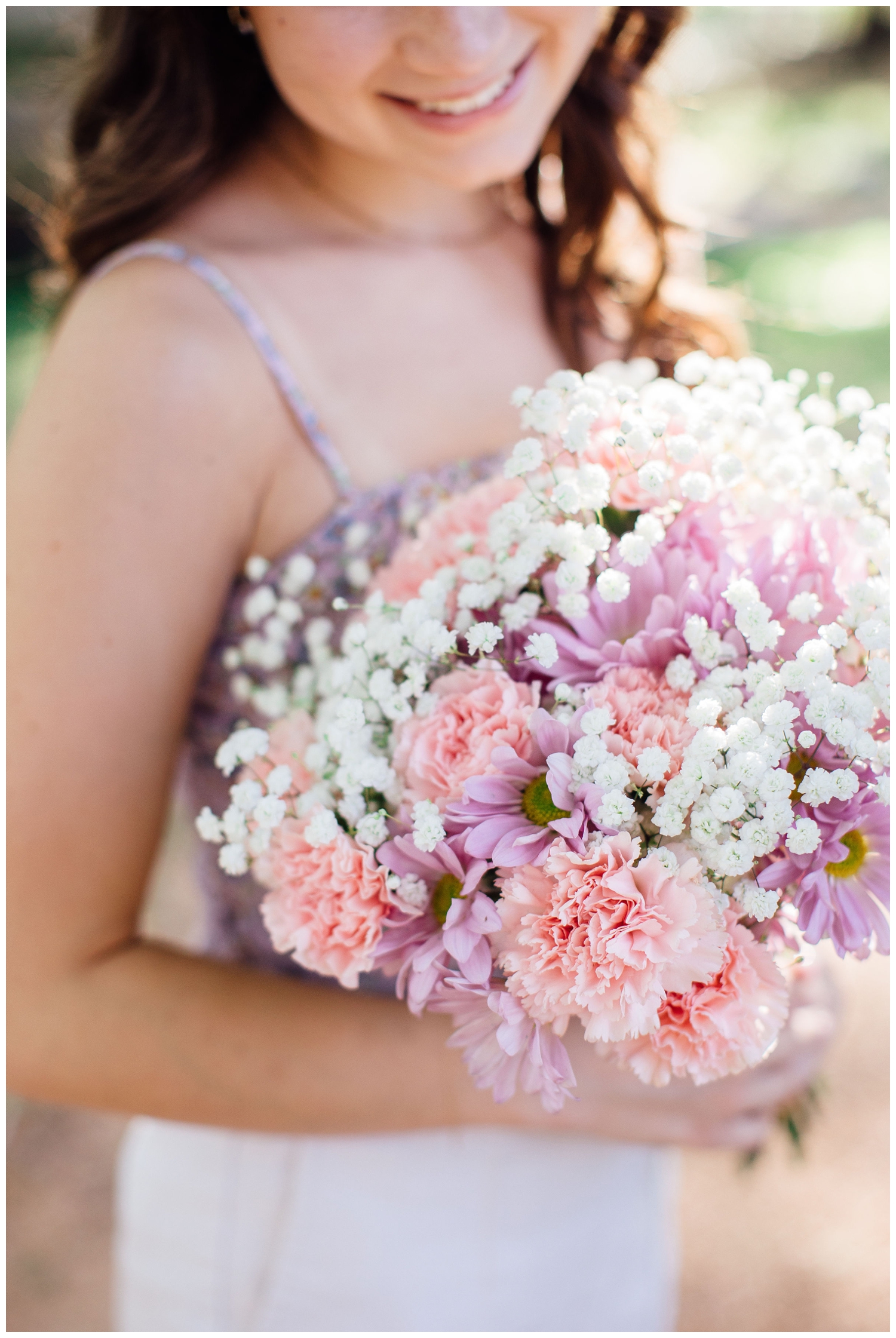 close up of senior girl holding pink purple bouquet