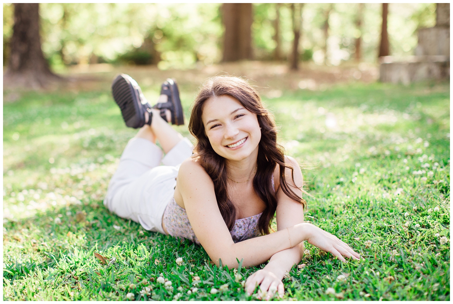 girl laying in the grass for spring senior photos Houston