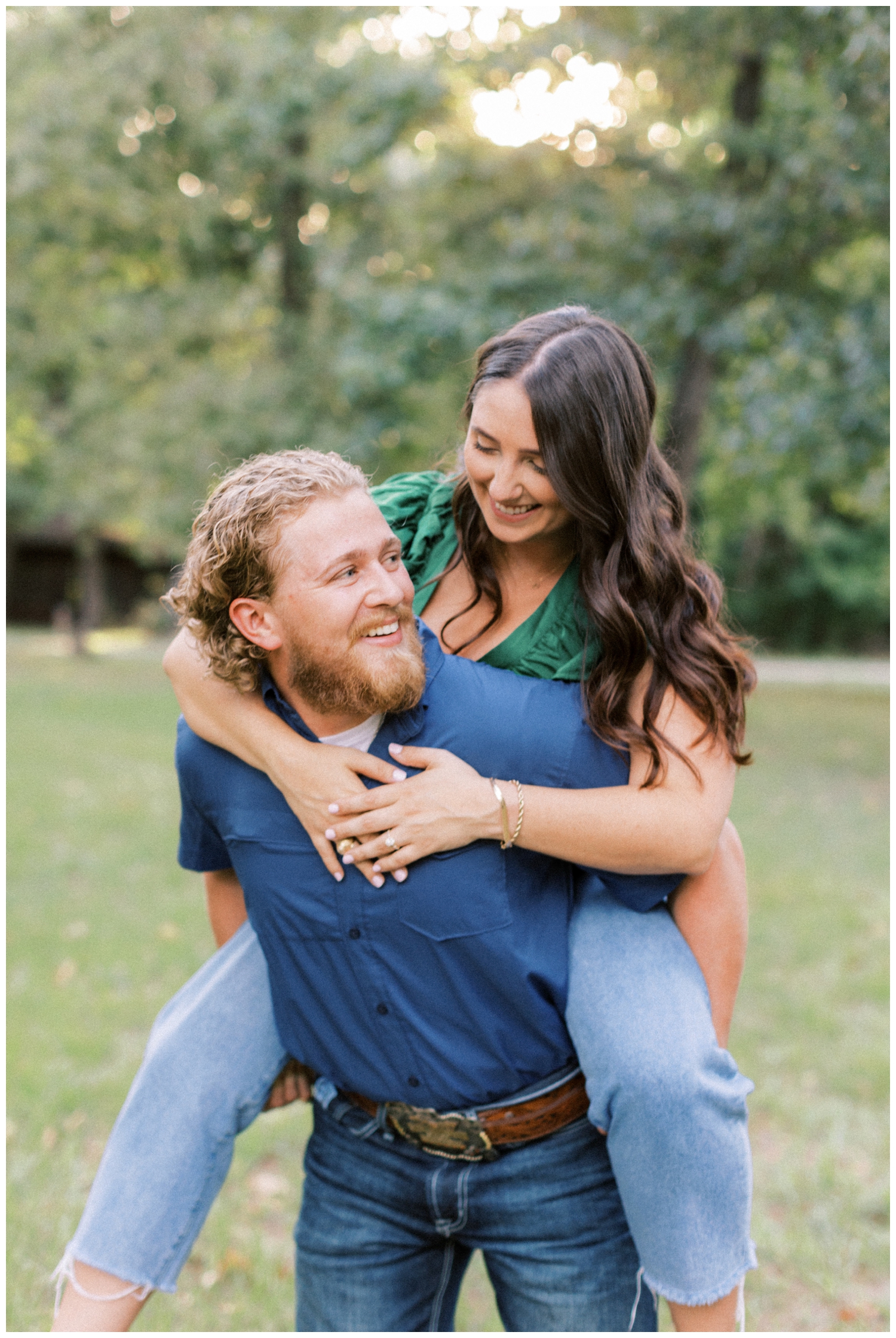 couple laughing riding piggy back during engagement photos Huntsville Texas