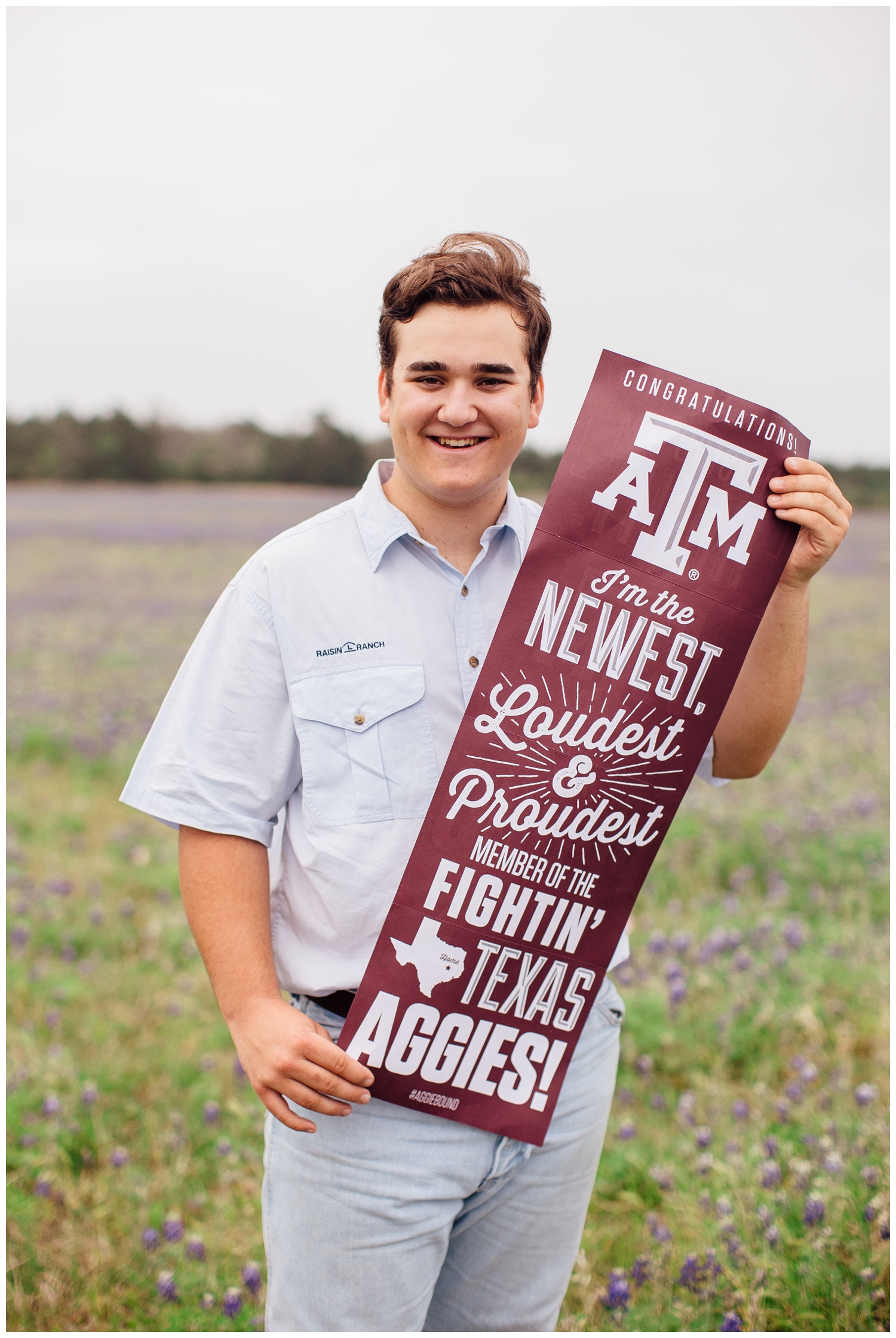 high school senior guy holding Texas Aggie sign outside in blue bonnet field