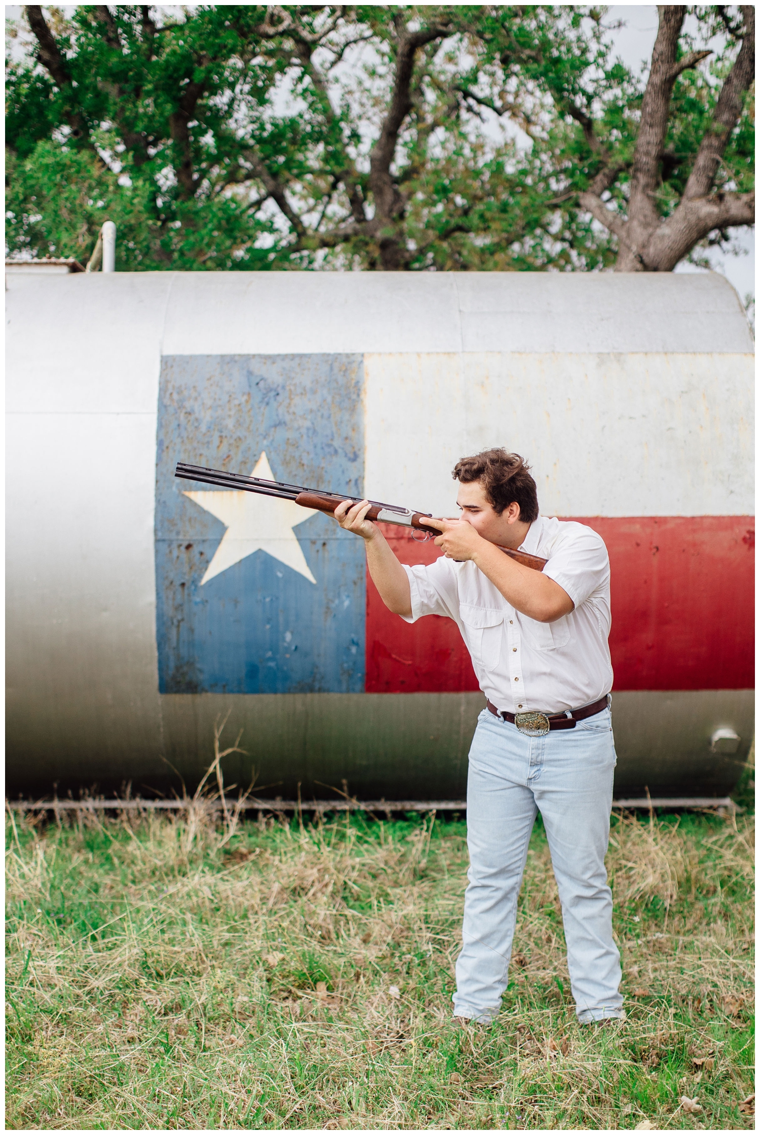 Houston high school senior guy holding rifle in field