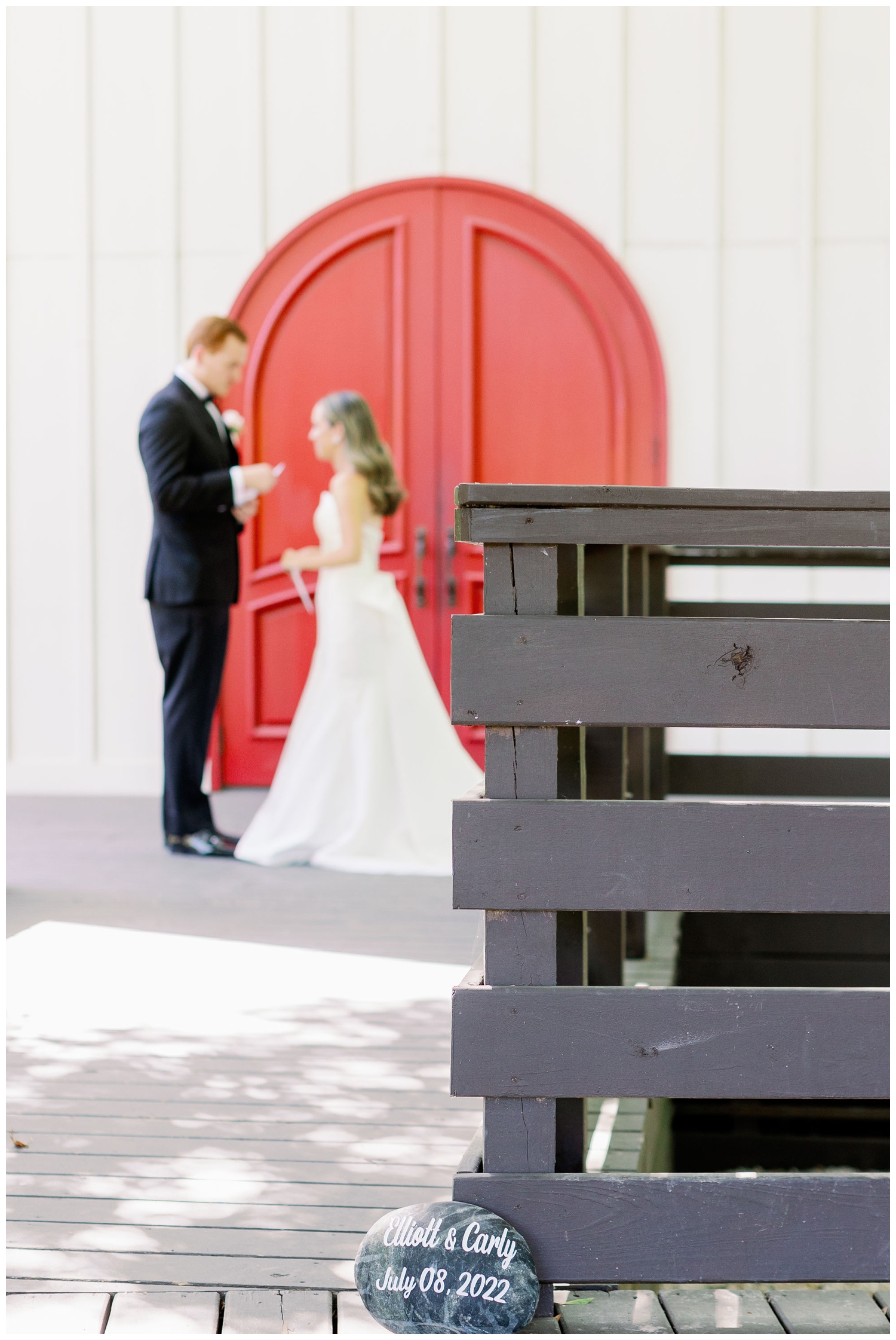 groom reading vows in front of red door at The Carriage House Houston during first look with bride