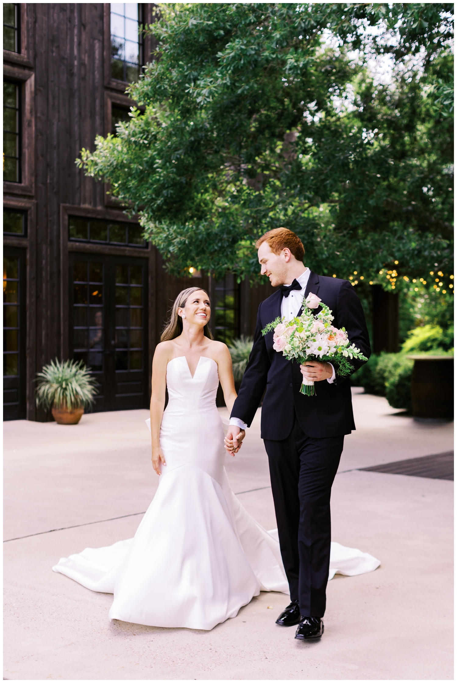 bride and groom holding hands and walking in front of The Carriage House Houston