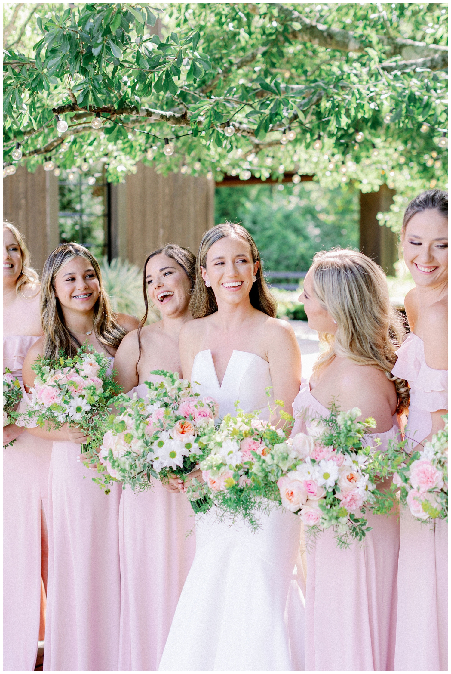 bride laughing outdoors with bridesmaids The Carriage House Houston