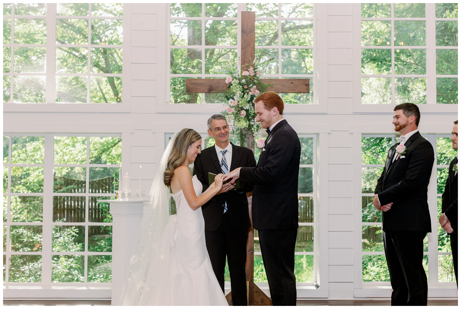 bride and groom ring exchange during wedding ceremony inside chapel at The Carriage House