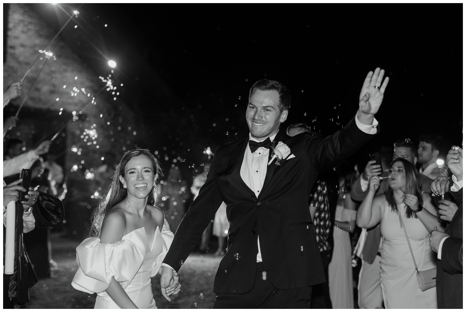 black and white image exiting reception with sparklers