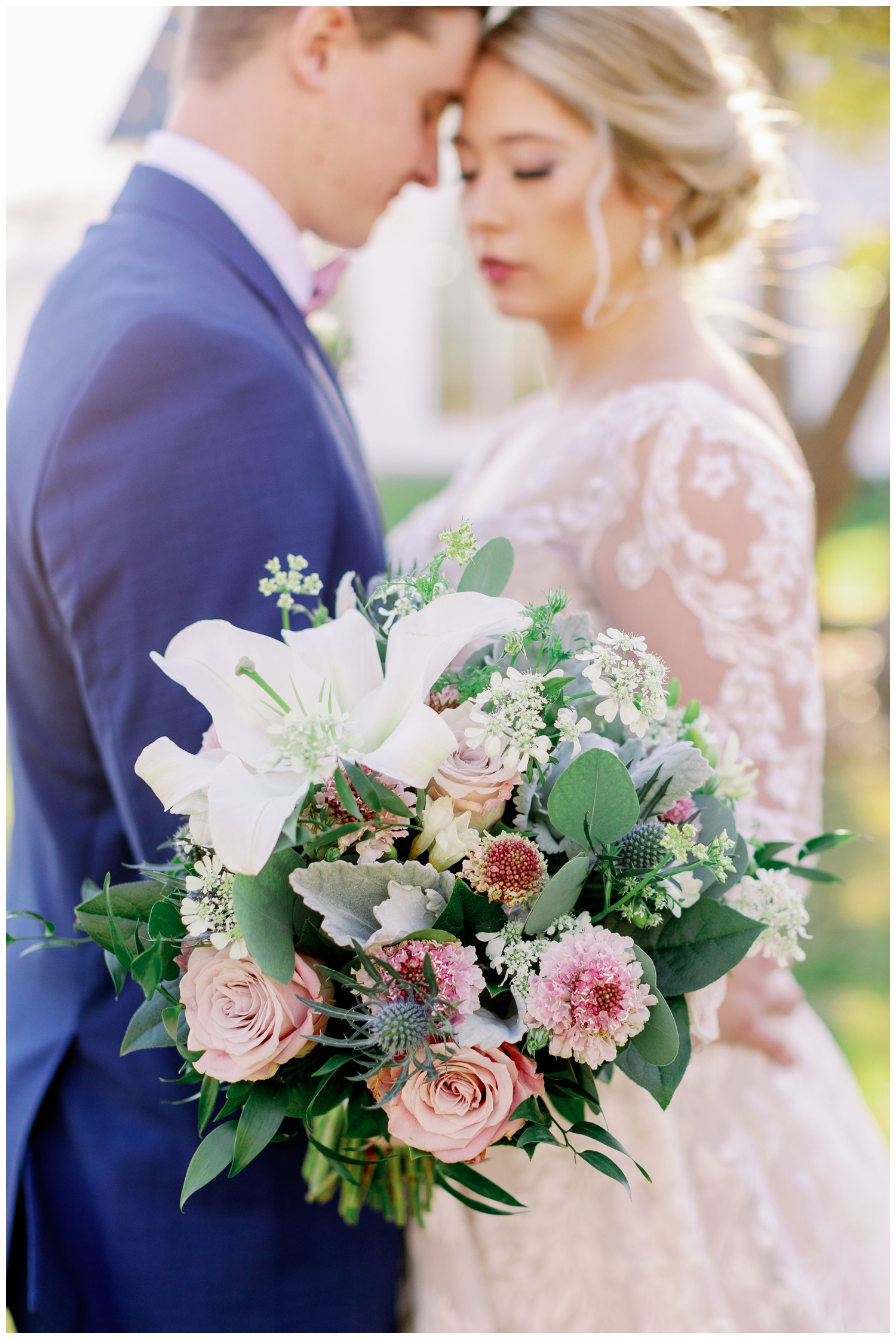 pink and white bouquet in foreground with bride groom in background
