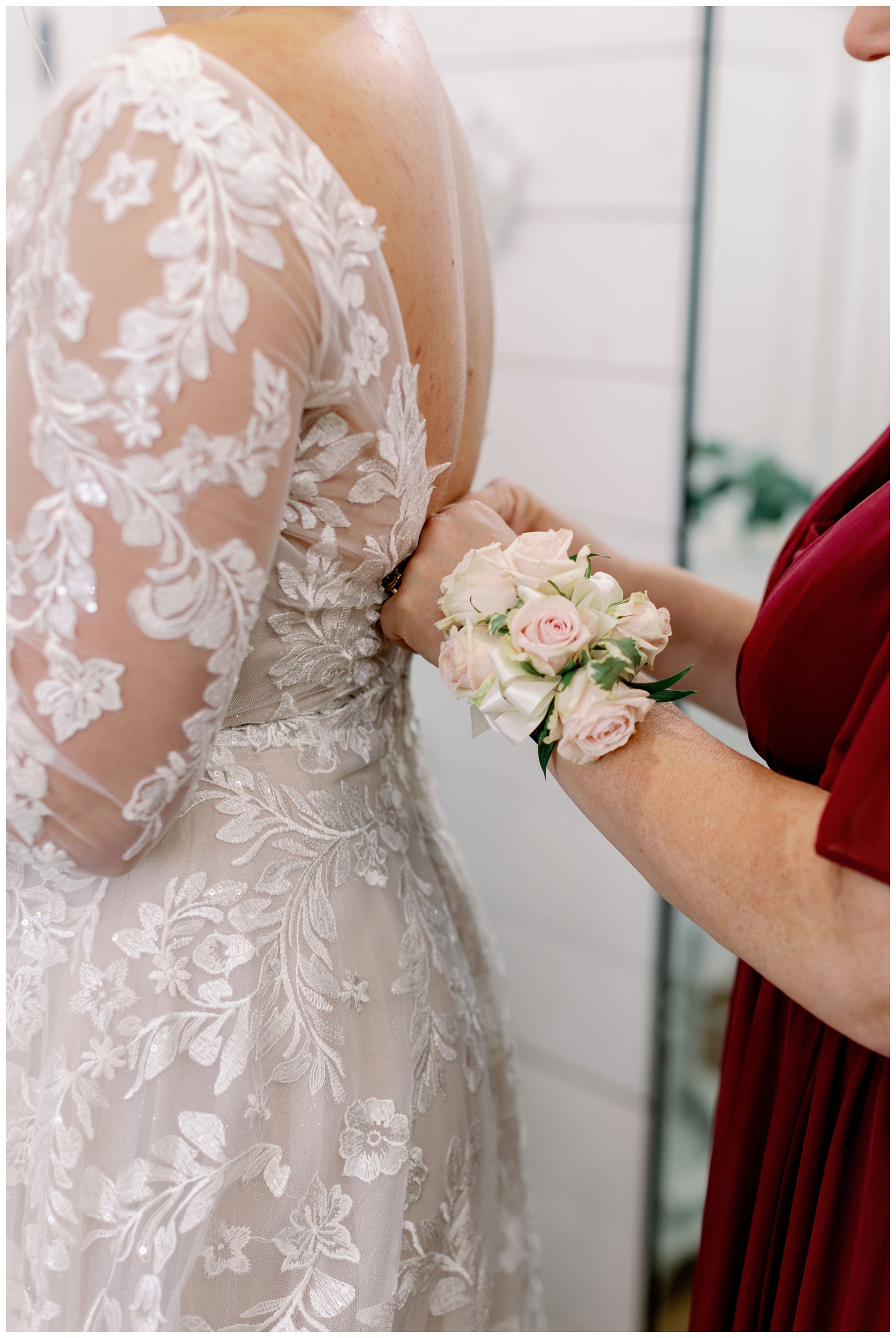 mother of bride buttoning bride's dress