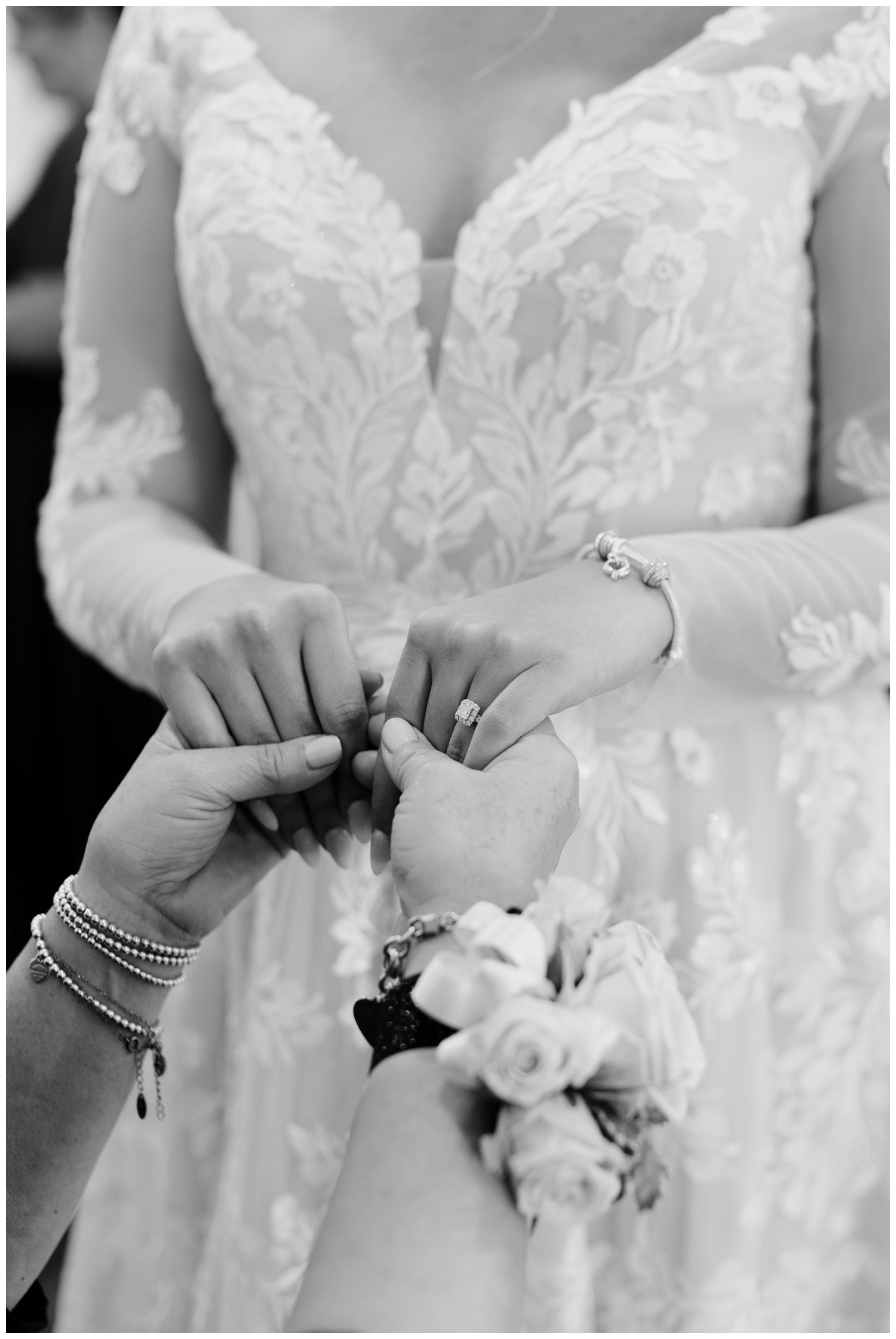 black and white close up image of bride and mother of bride holding hands