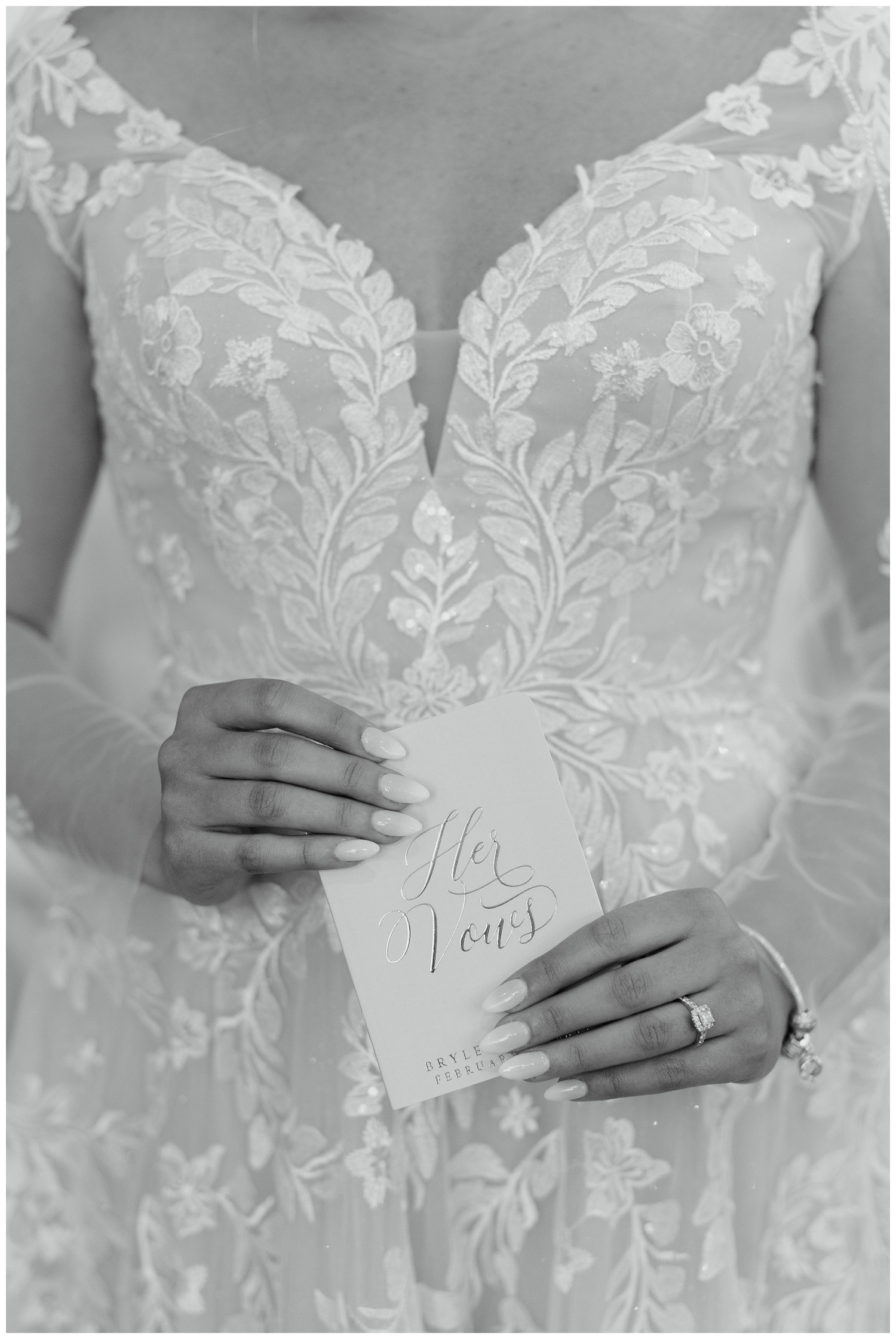 black and white image of bride's hands holding vow book