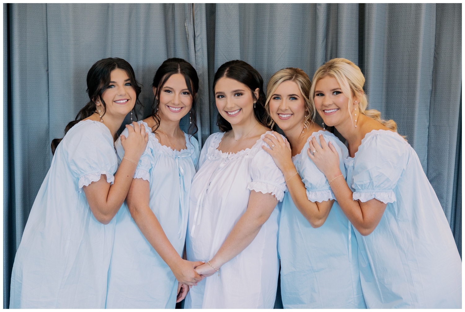 bride and bridesmaids wearing blue pajamas inside Bluebird Haven Estates Wedding venue