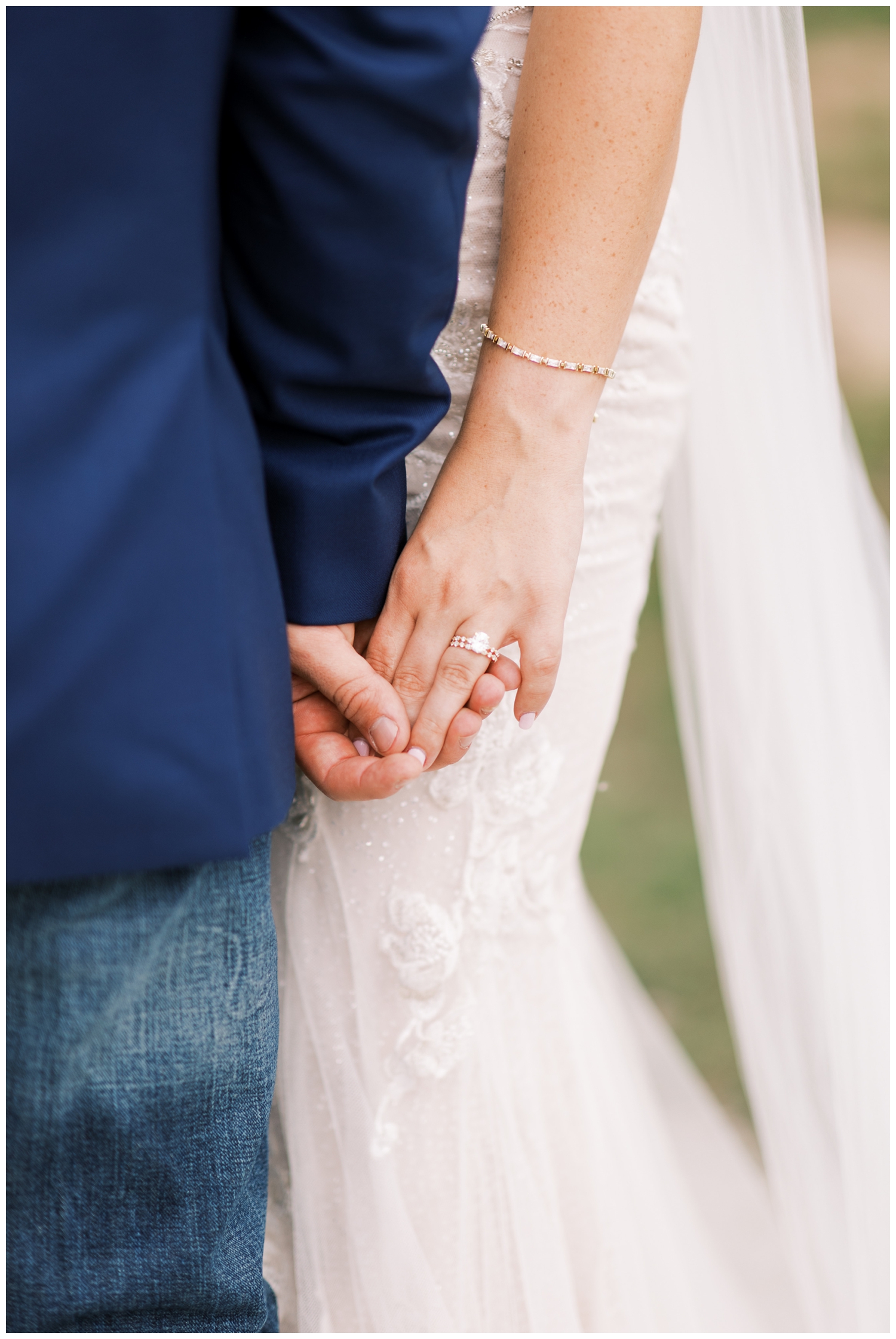 detailed image of bride and groom holding hands down by their side