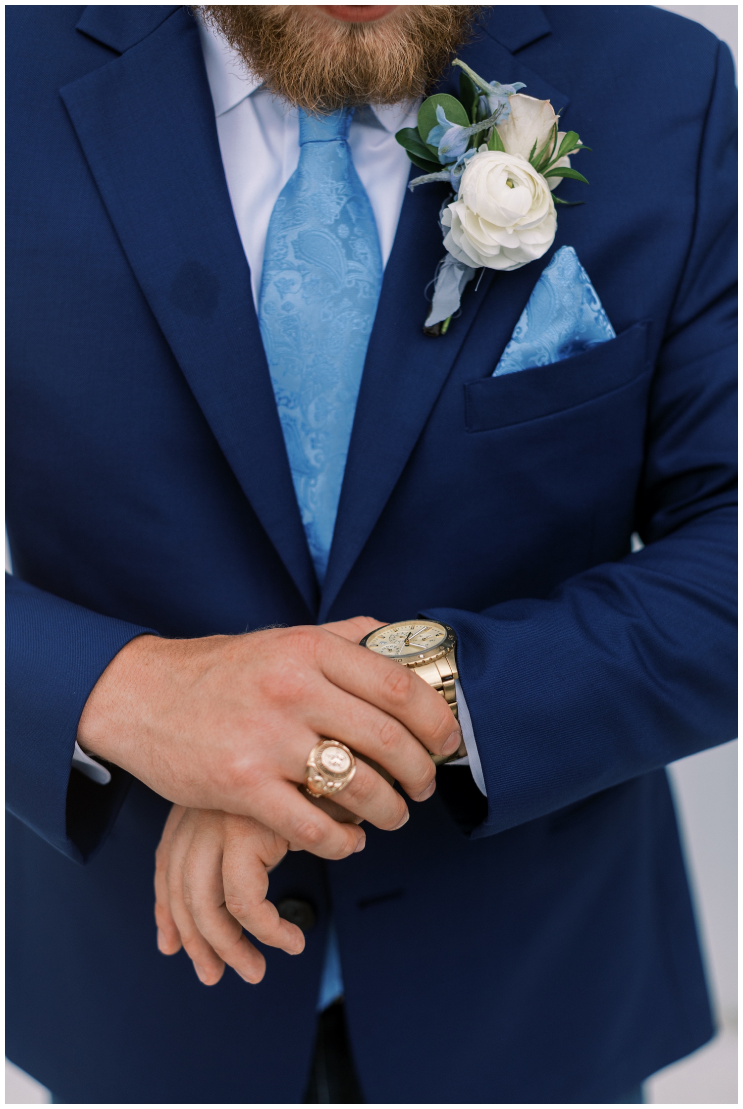 groom in blue tux with hand on watch for Bluebird Haven Estates Wedding in Madisonville Texas