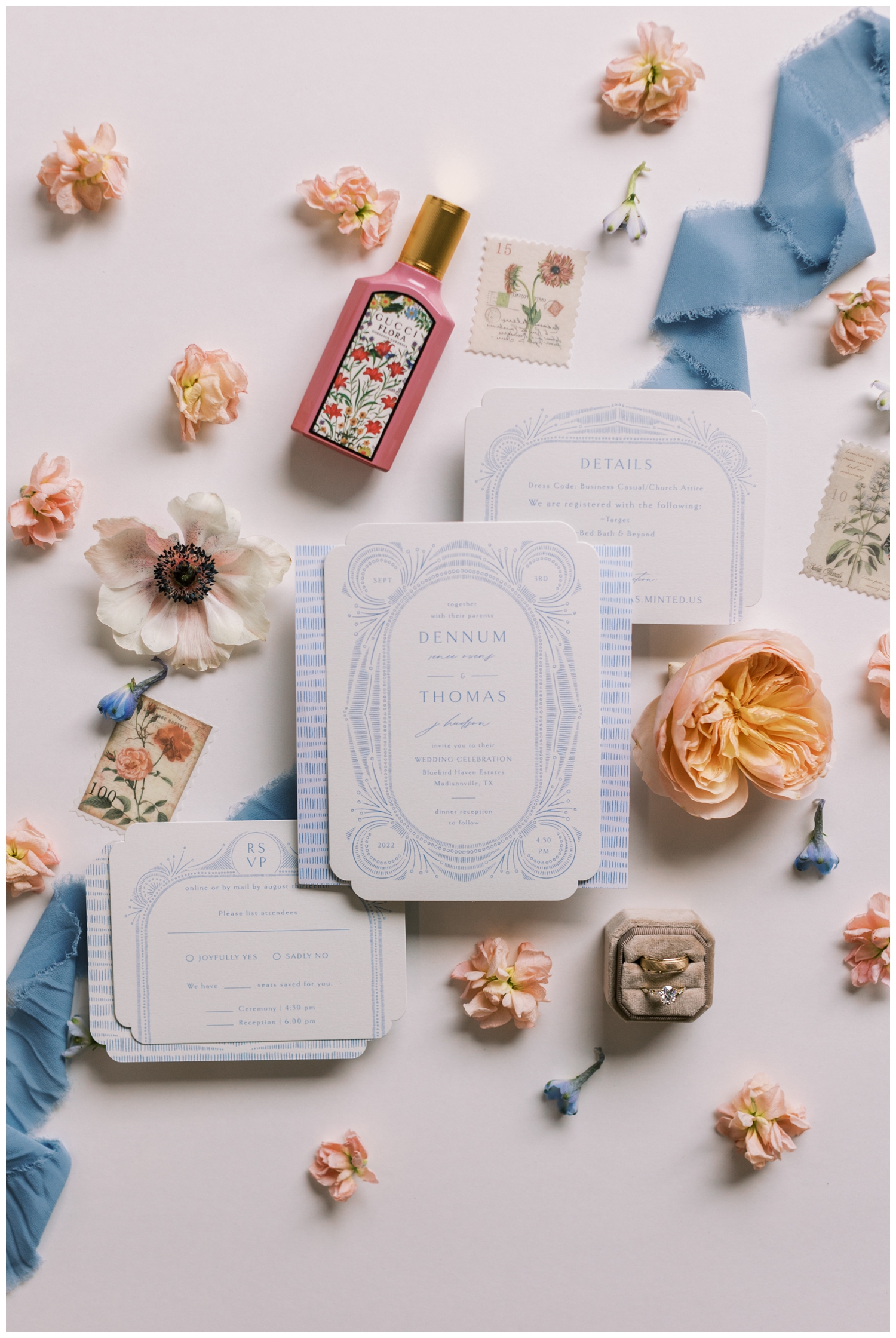 white and blue invitation suite surrounded by florals