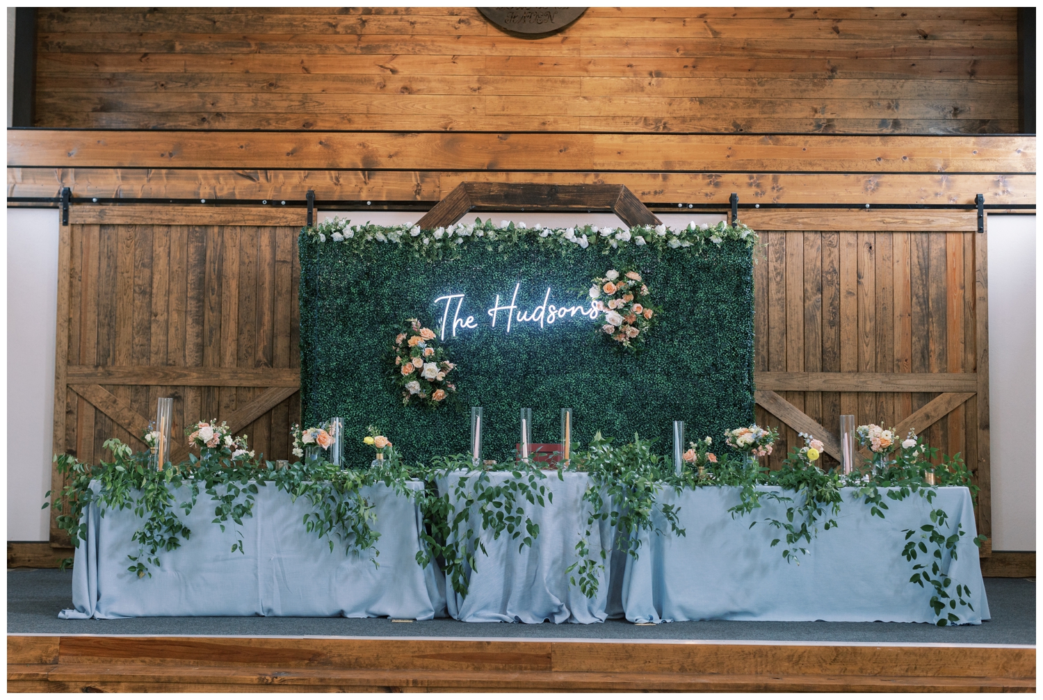baby blue sweetheart table with light up neon sign inside reception at Bluebird Haven Estates