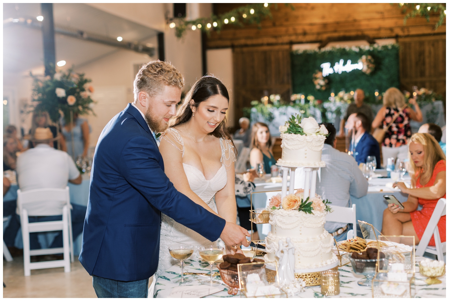 bride and groom cutting three tier white wedding cake