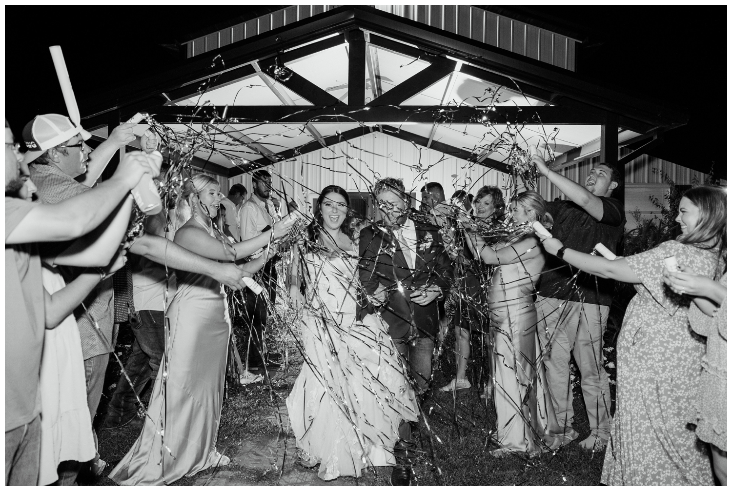 black and white image of bride and groom streamer exit