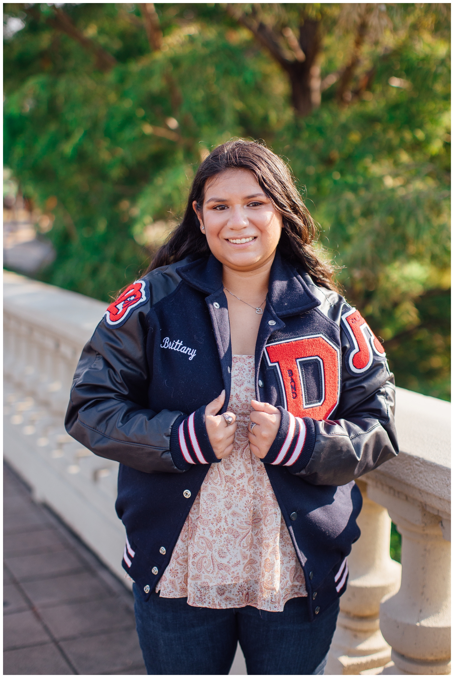 girl in navy and red letter jacket posing on Sabine Bridge Senior Photos in Houston,Texas