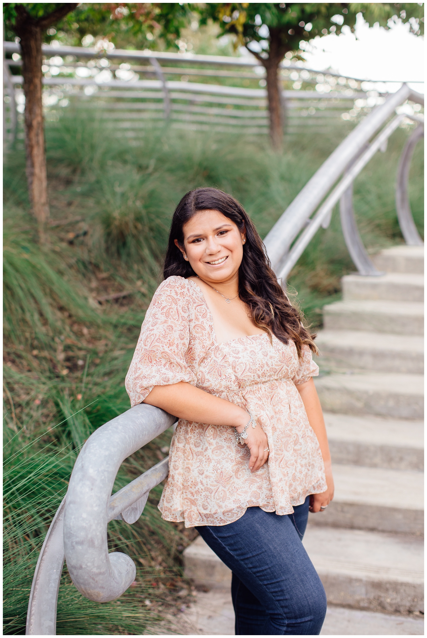 Senior Photos in Houston with girl in floral blouse and jeans on stairs