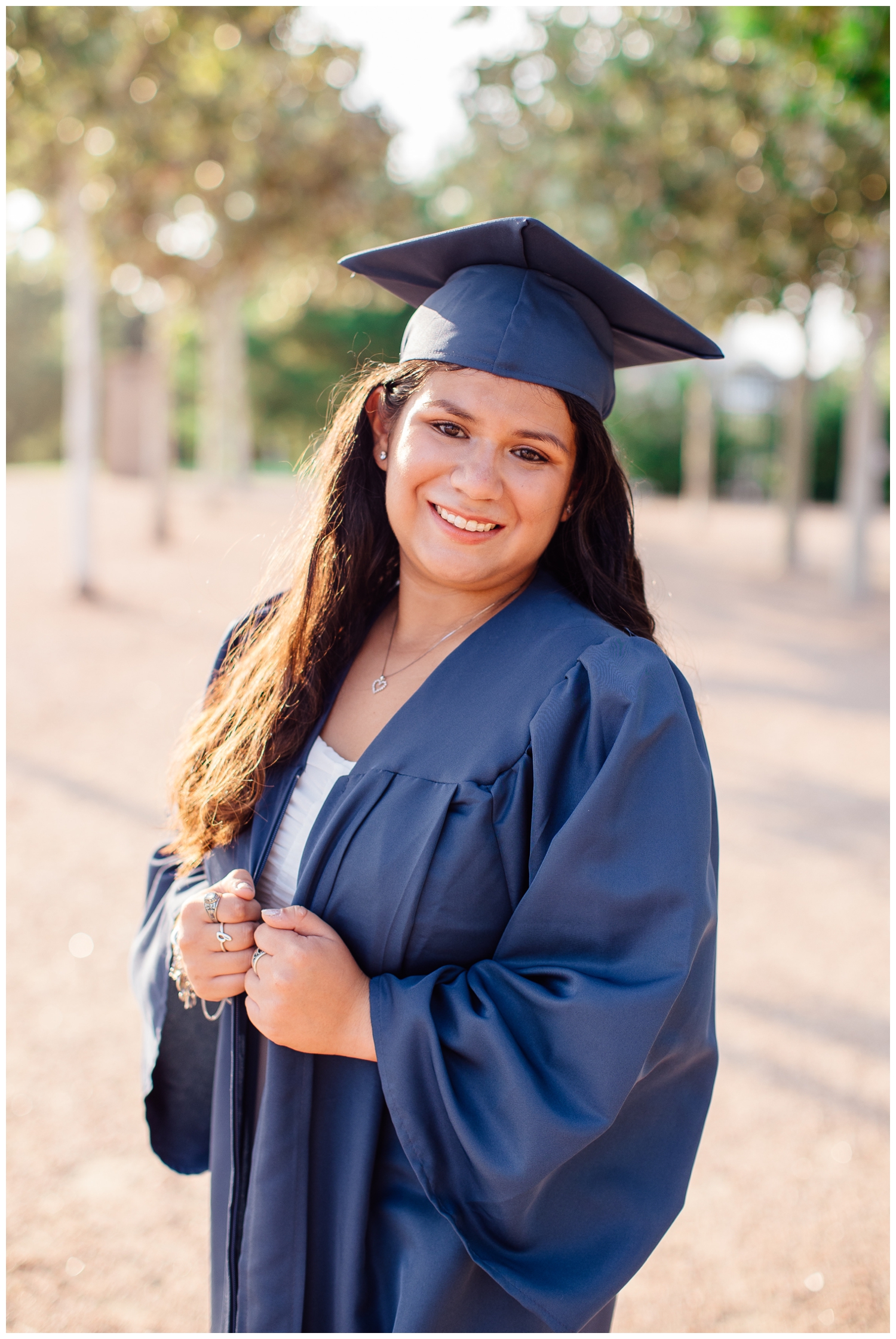 high school senior girl in cap and graduation gown smiling at camera
