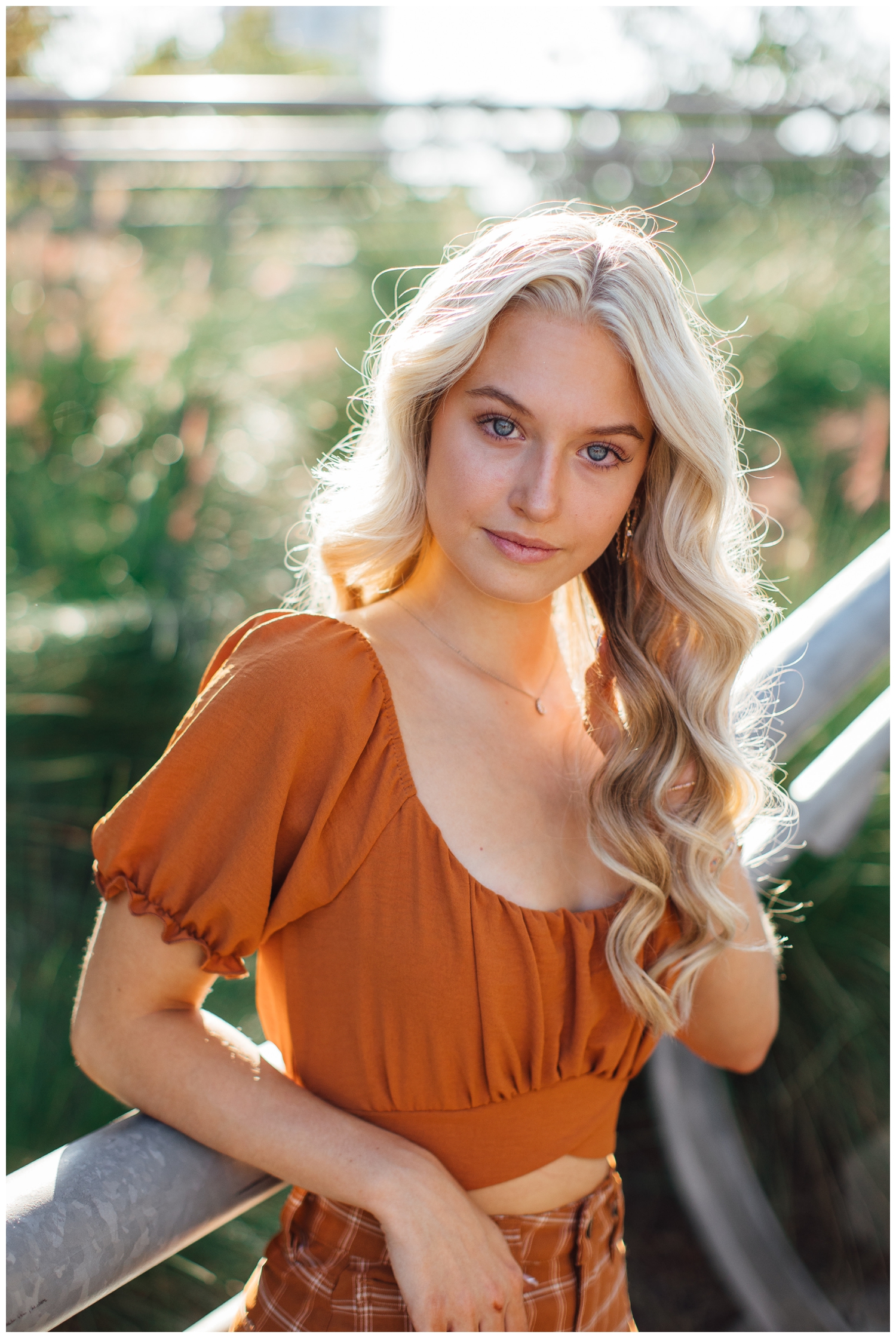 closeup portrait of high school senior girl in rust blouse outdoors Houston