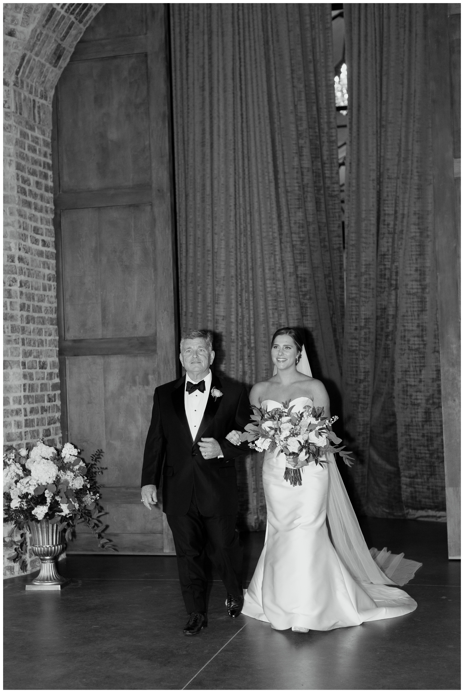black and white image of bride and father entering elegant Iron Manor wedding ceremony