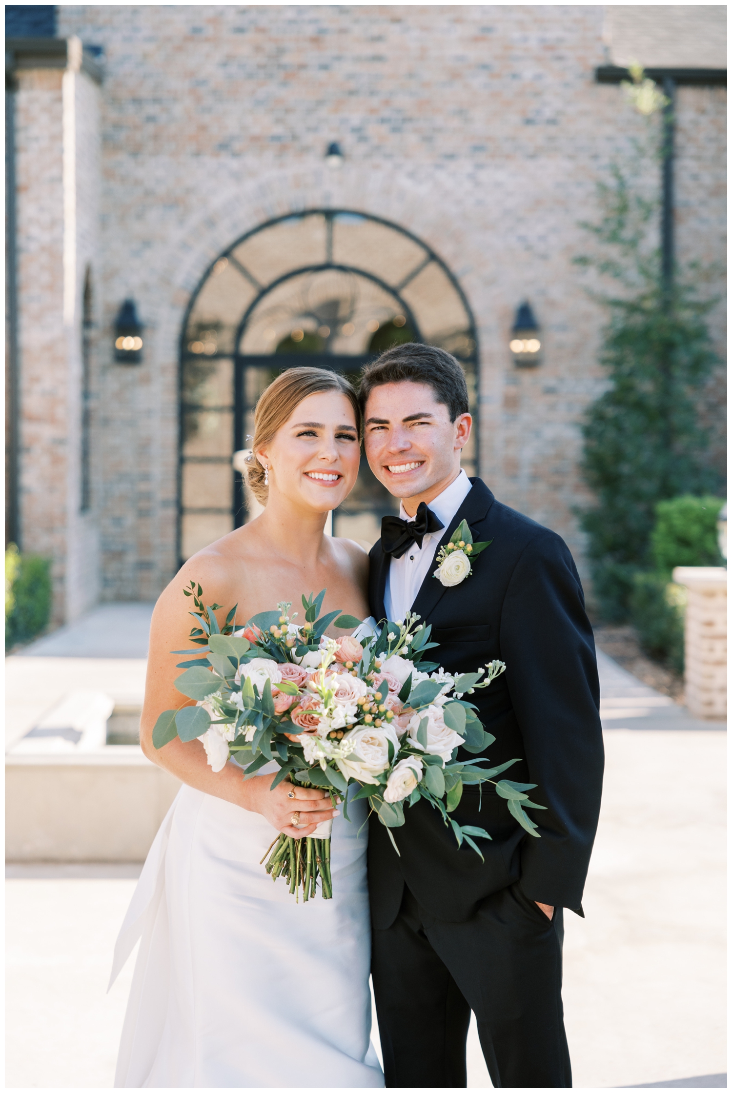 elegant Iron Manor Wedding portrait of bride and groom cheek to cheek outdoors with colorful bouquet