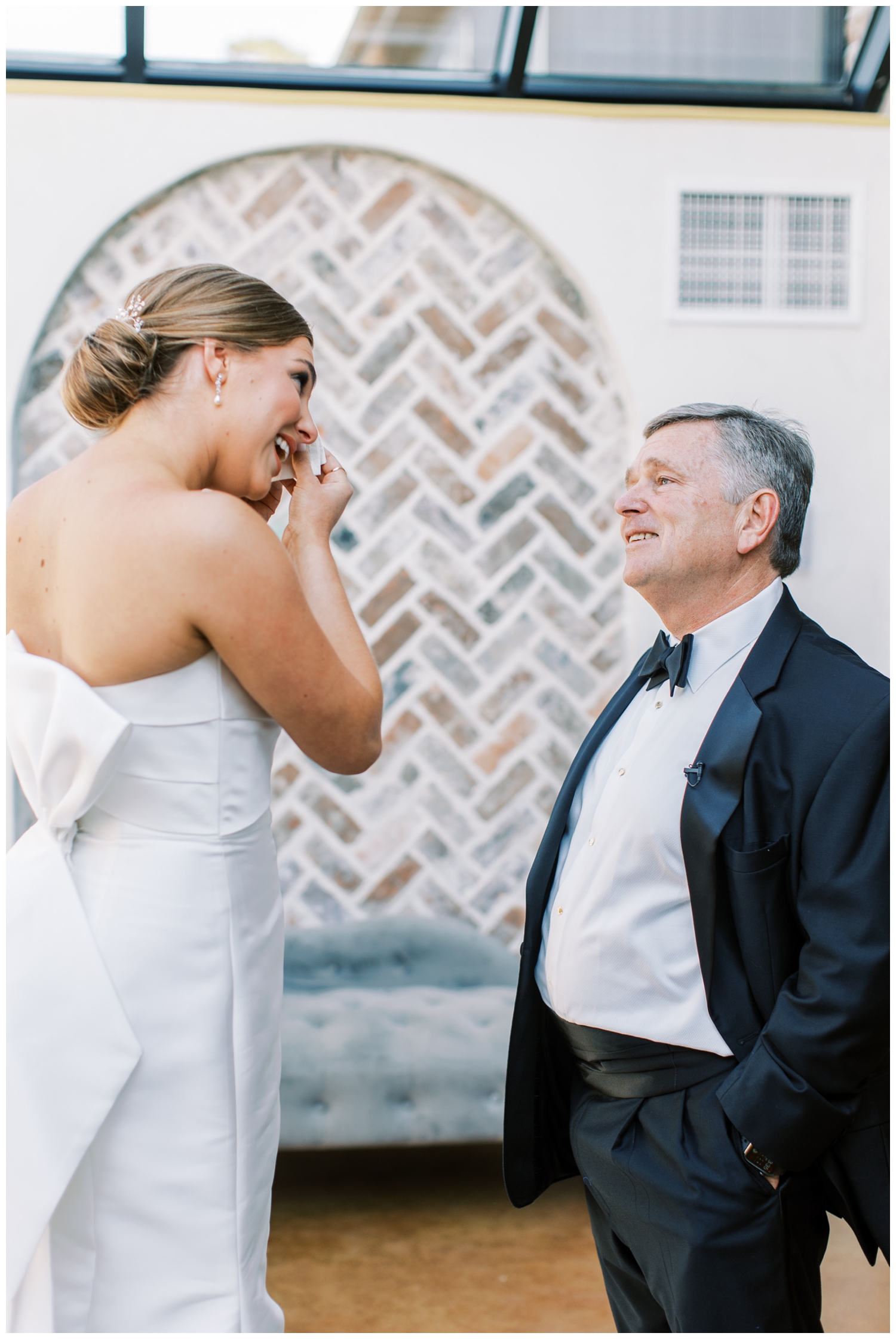 bride wiping tears after father daughter first look with Dad smiling at her