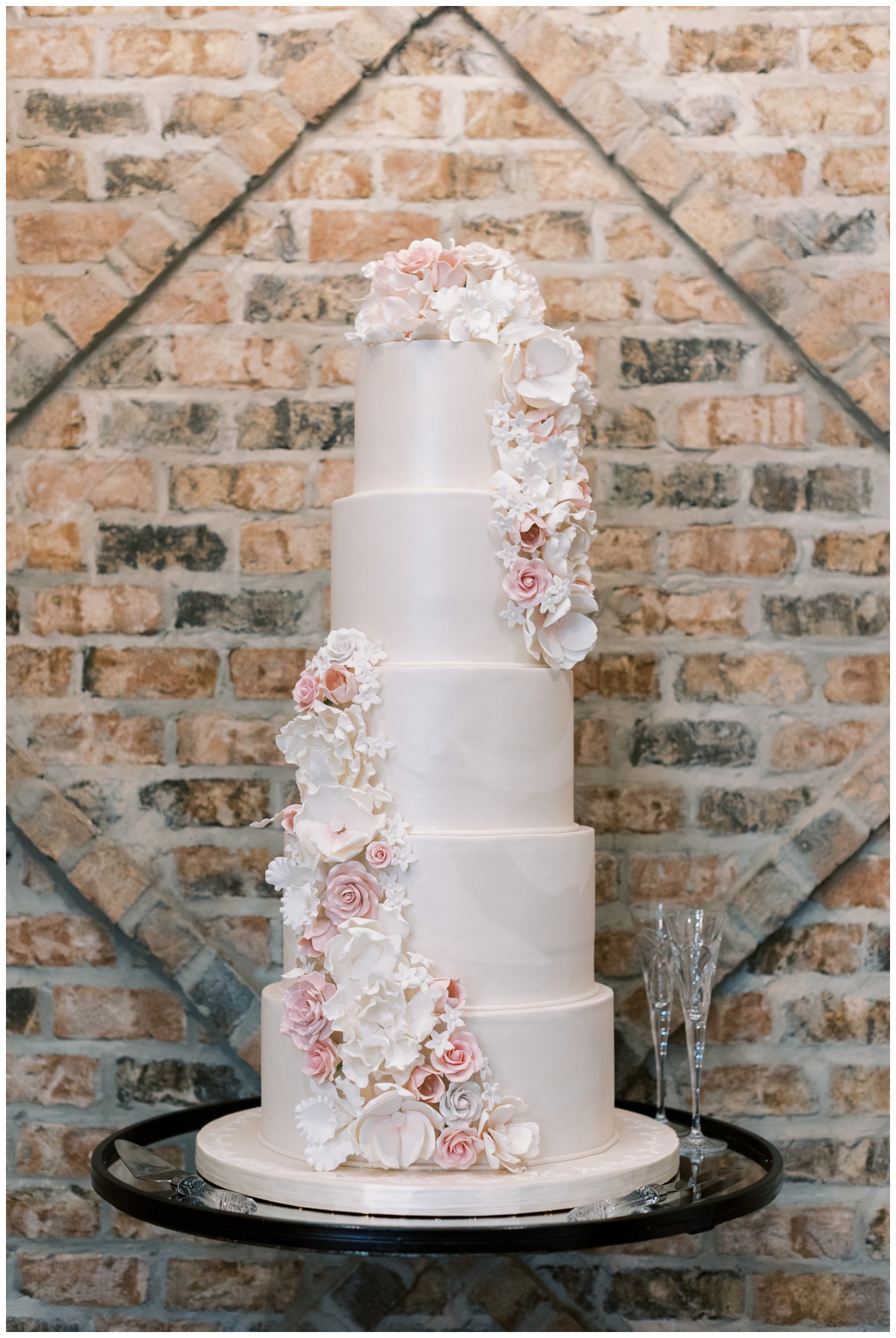 five tier white wedding cake with white and blush florals inside Iron Manor