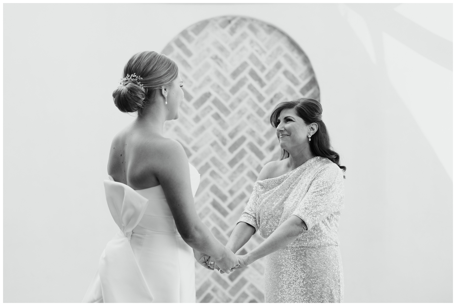 mom holding brides hand and smiling inside the elegant Iron Manor wedding bridal suite