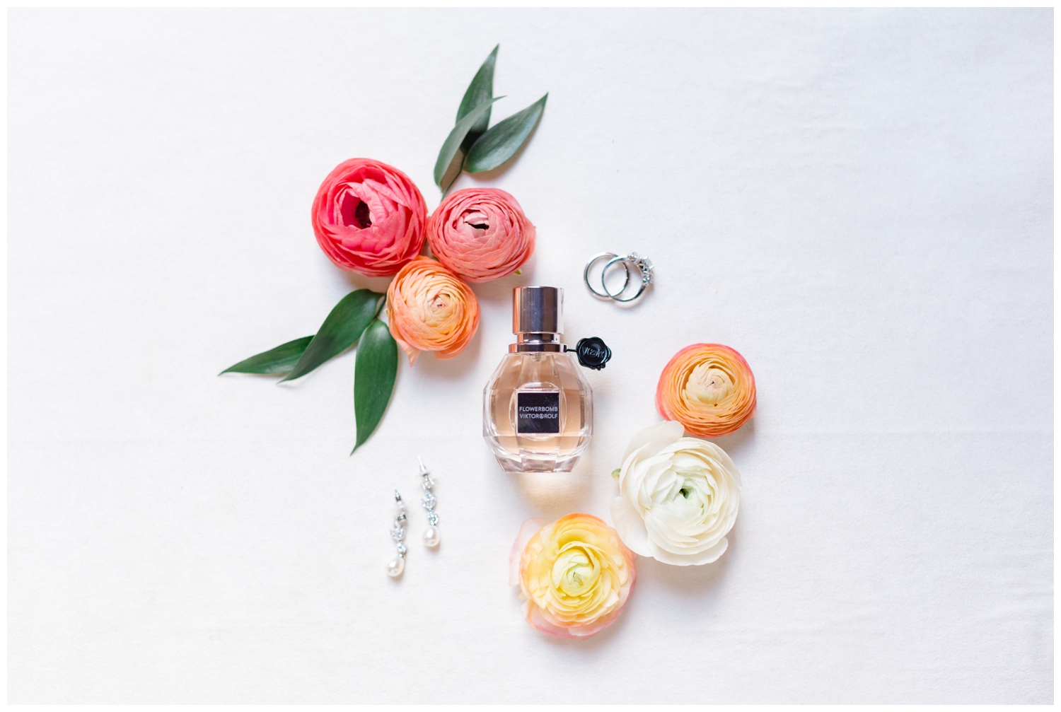 coral and peach florals surrounding pink perfume bottle for elegant Iron Manor Wedding