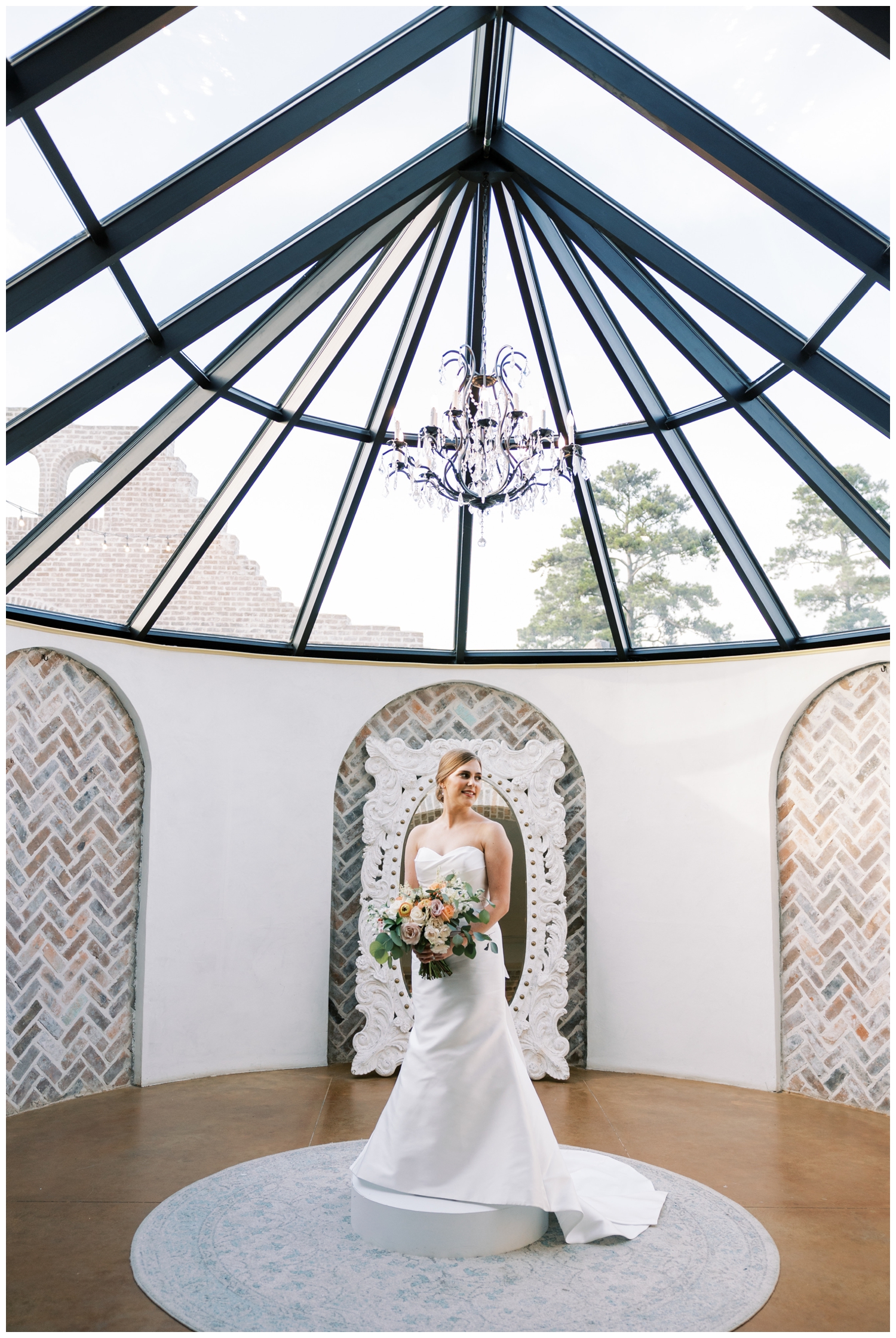 bride standing inside Iron Manor bridal suite posing with bouquet
