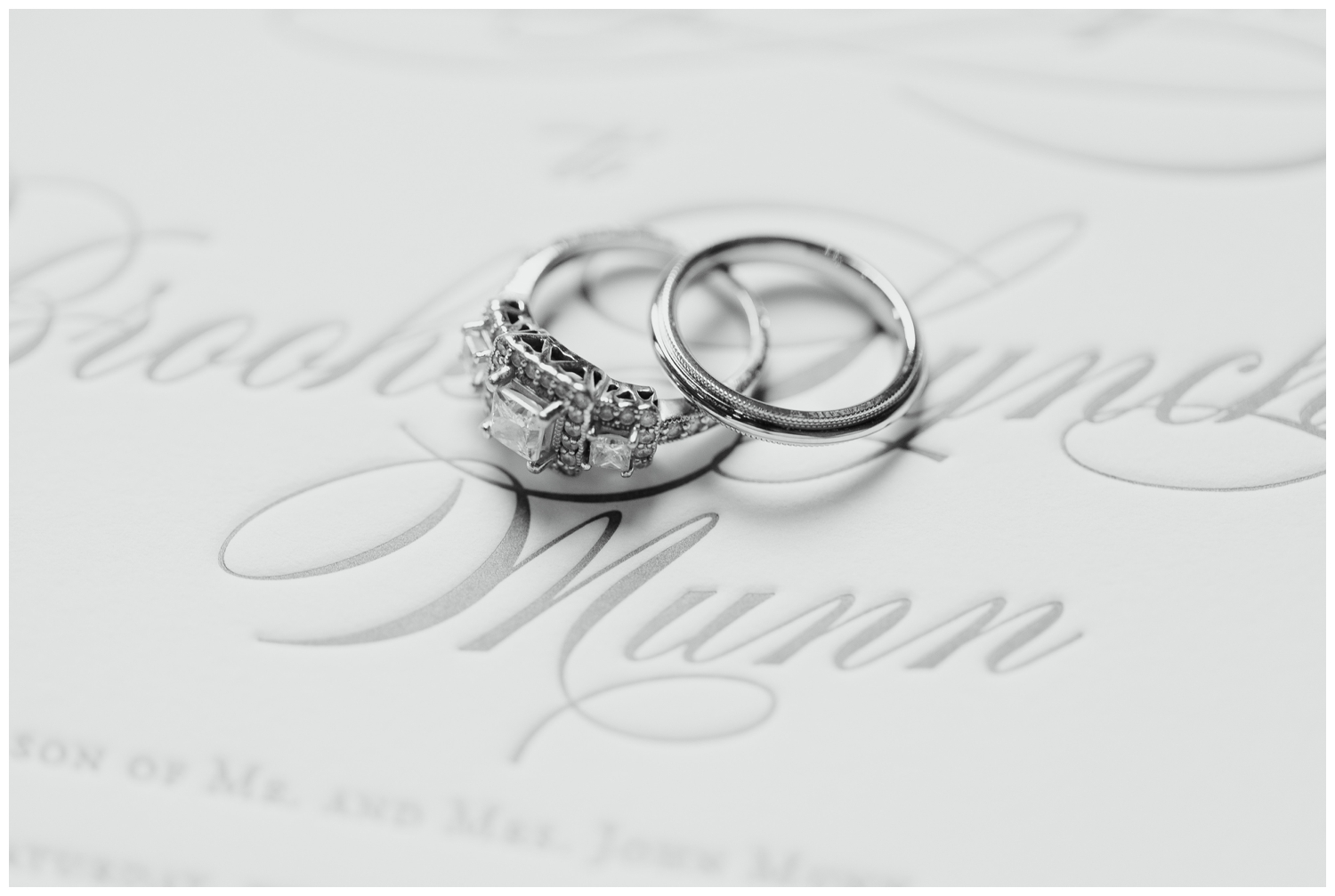 platinum rings laying on white invitation suite