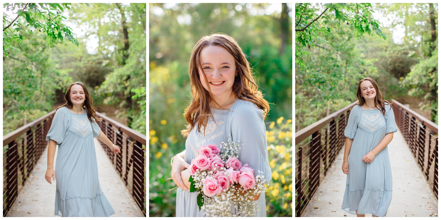 Houston senior photos with flowers with girl in blue dress standing on a bridge at Houston Arboretum
