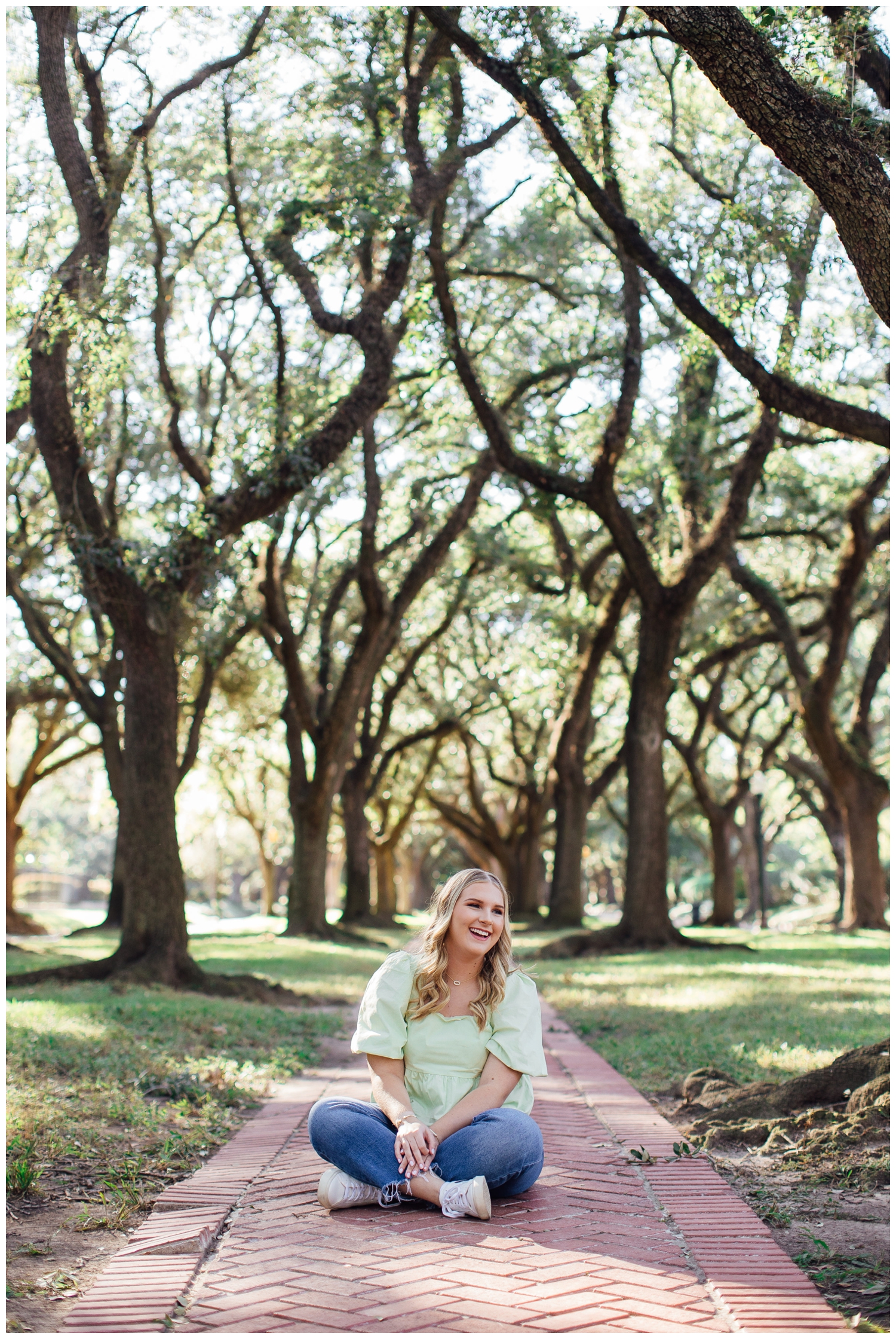 high school senior girl sitting between trees at North South Blvd Houston