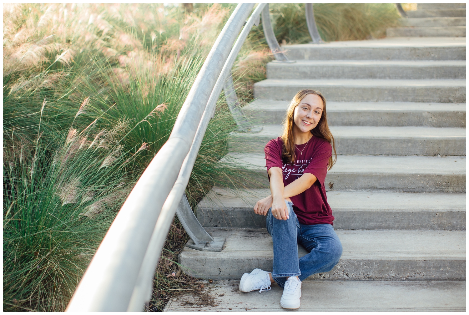 high school girl in jeans and maroon shirt sitting on stairs in downtown Houston senior pictures