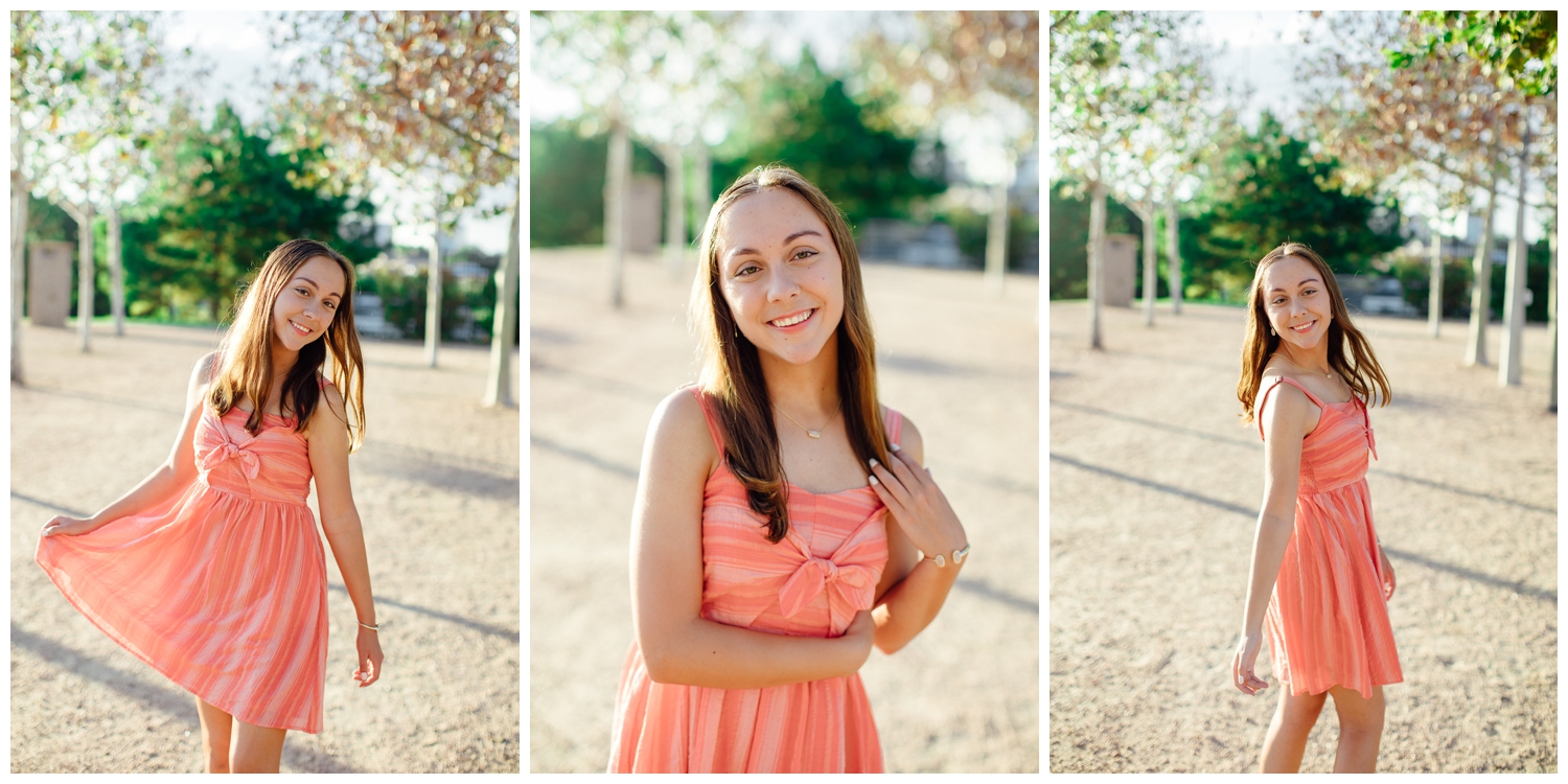 girl in coral sundress walking in tree line in downtown Houston senior picture