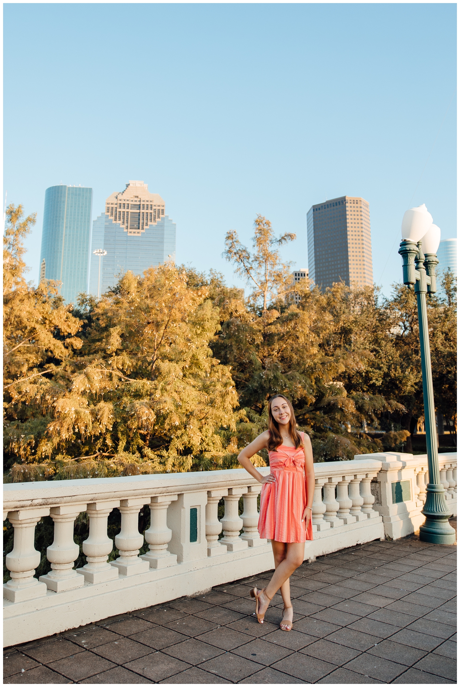 downtown Houston senior pictures with girl in dress standing with skyline in background