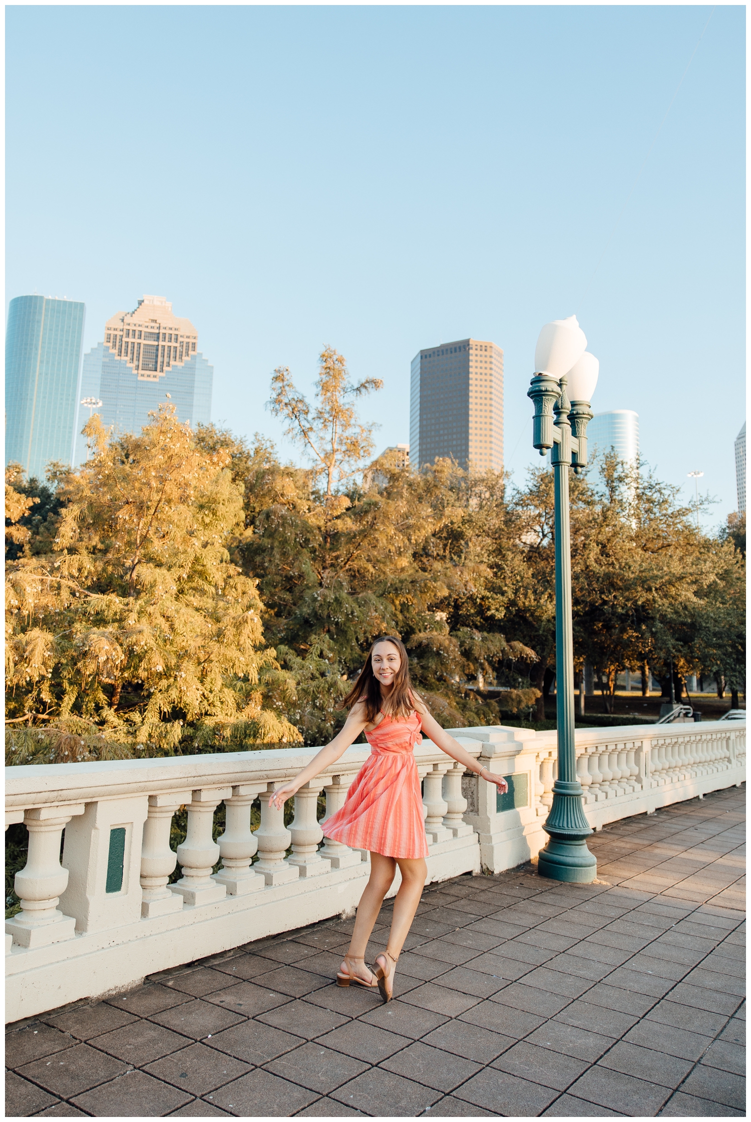 downtown Houston senior pictures with skyline background girl in coral dress
