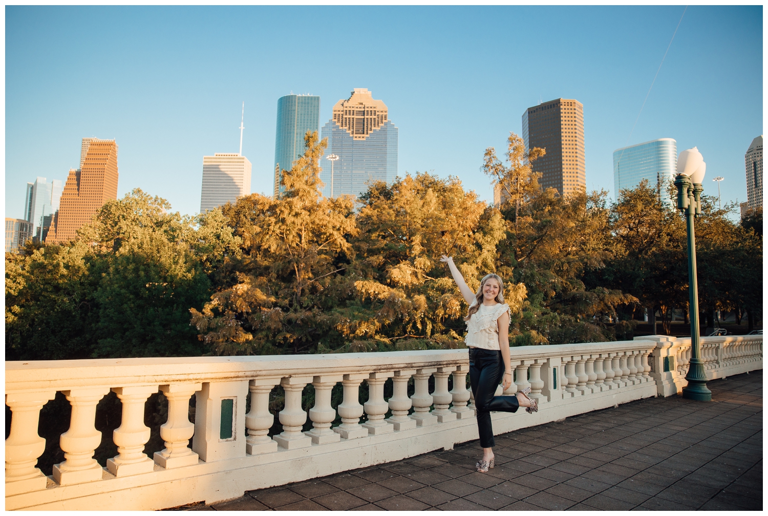 girl standing on Sabine Street bridge in front of Houston skyline
