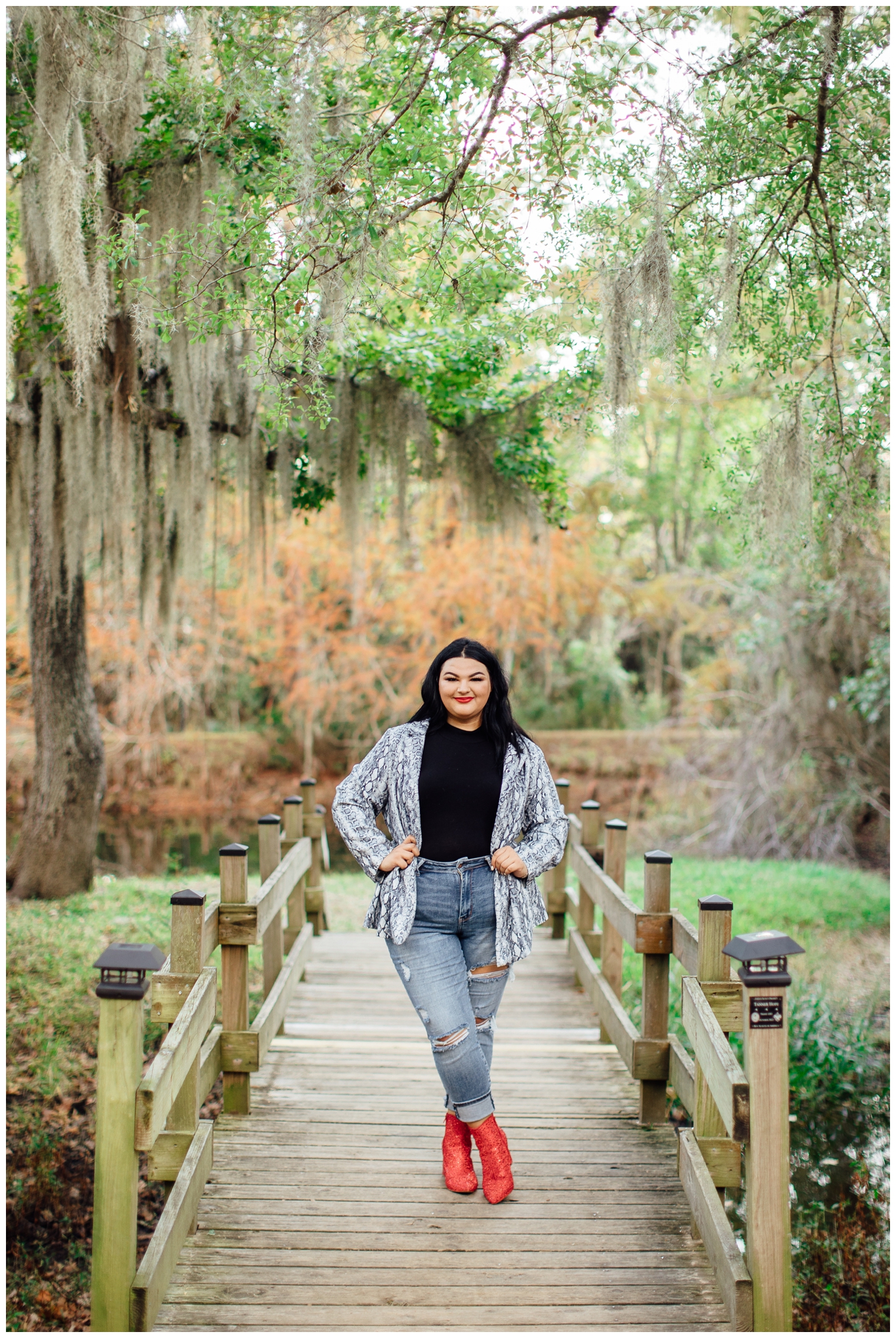 high school senior girl standing on bridge at Cy Hope Cypress in jeans and black shirt